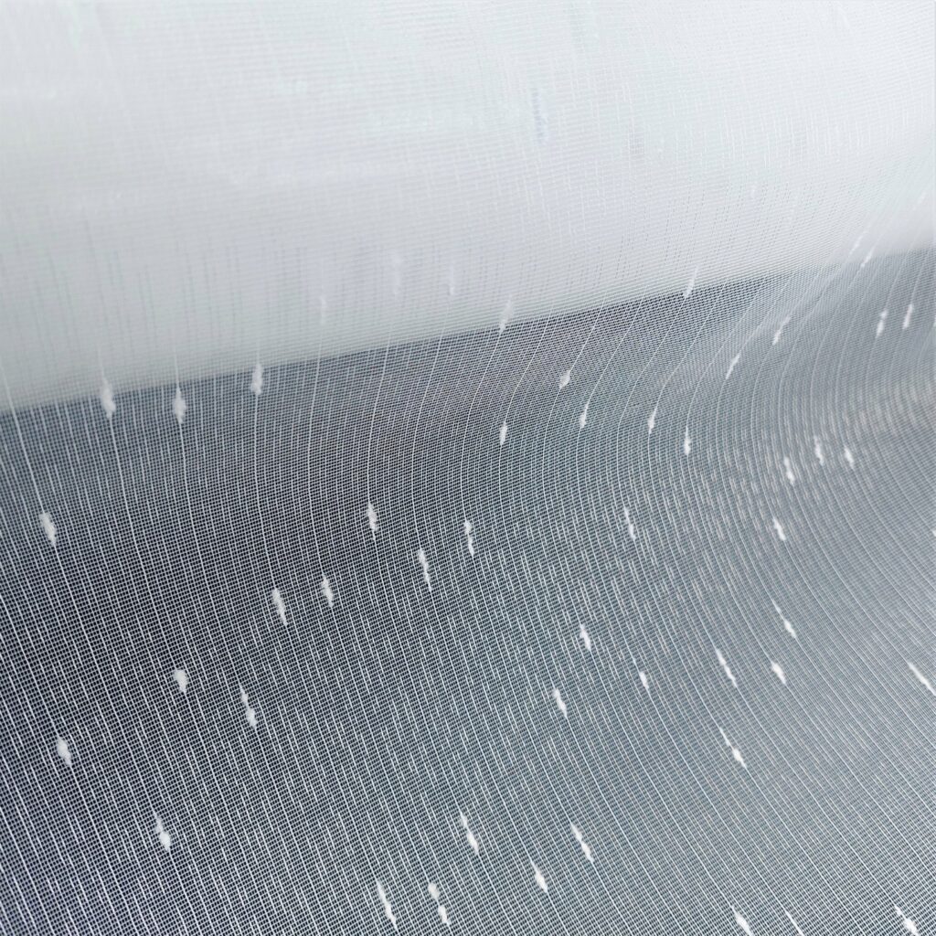 163-3 Przezroczysta tkanina z białymi wzorami w groszki, delikatna i elegancka, idealna na zasłony lub dekoracje.