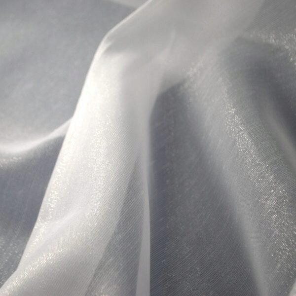 Przezroczysty materiał organza w świetle, delikatne fałdy i połysk na powierzchni tkaniny.