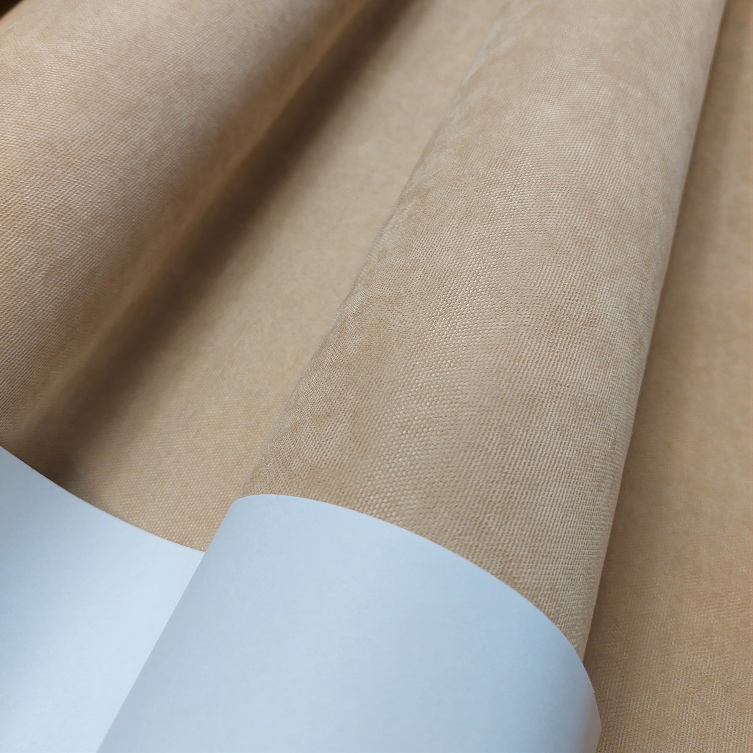 Zbliżenie na beżowy materiał rolki tapety, tekstura z delikatnym wzorem.