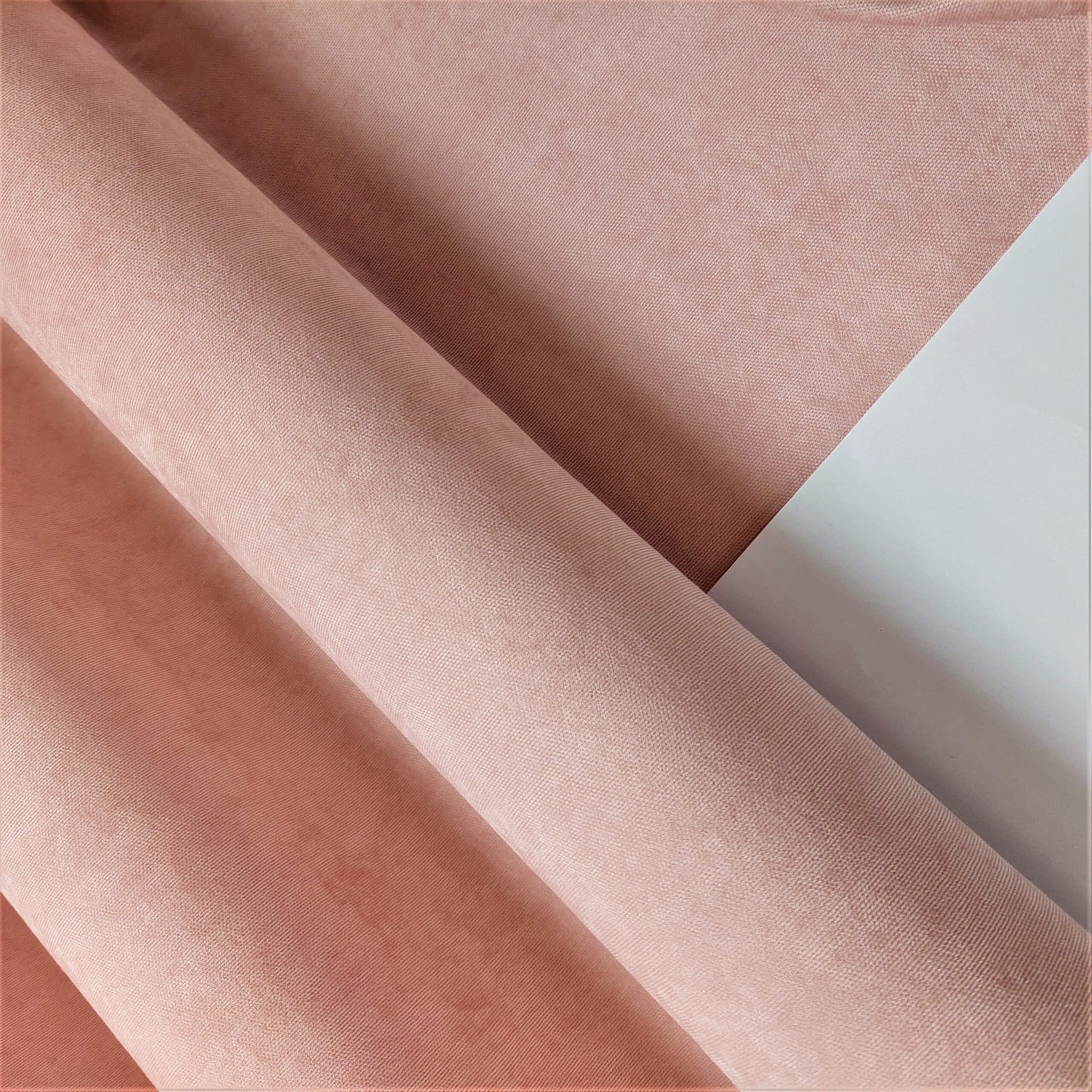 Różowa tkanina welurowa złożona na białym tle, widok z bliska. Idealna do dekoracji wnętrz.