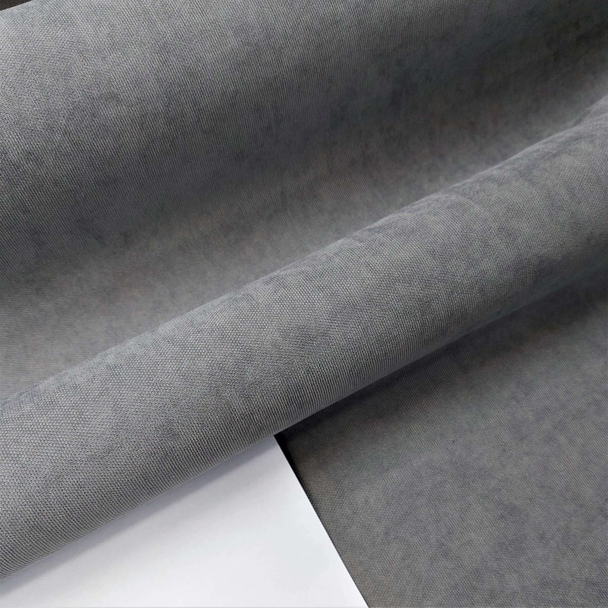 Szary materiał tapicerski w zbliżeniu, prezentujący teksturę i jakość tkaniny. Idealny do wnętrz nowoczesnych.