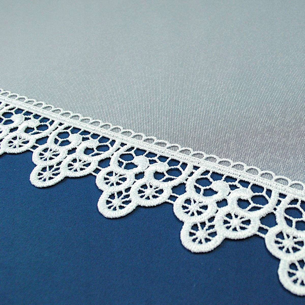 Biała koronka na niebieskim tle, dekoracyjny motyw, elegancki wzór.