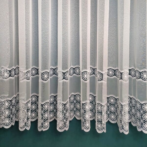 Koronkowa zasłona w białym kolorze z dekoracyjnym wzorem kwiatowym, idealna do wnętrz eleganckich.