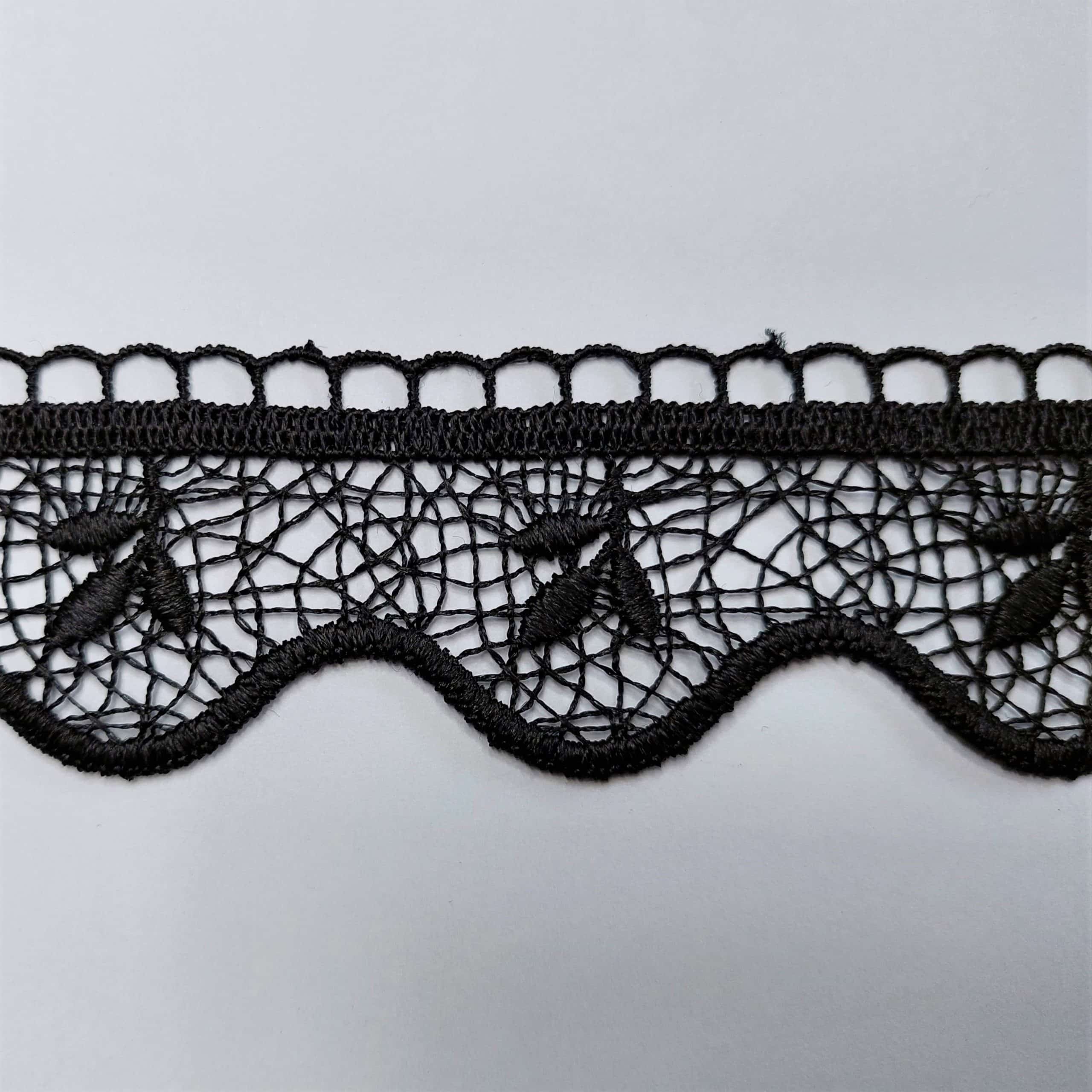 81884-5 2cz Czarna koronka z delikatnym wzorem na białym tle, elegancka i ozdobna tkanina.