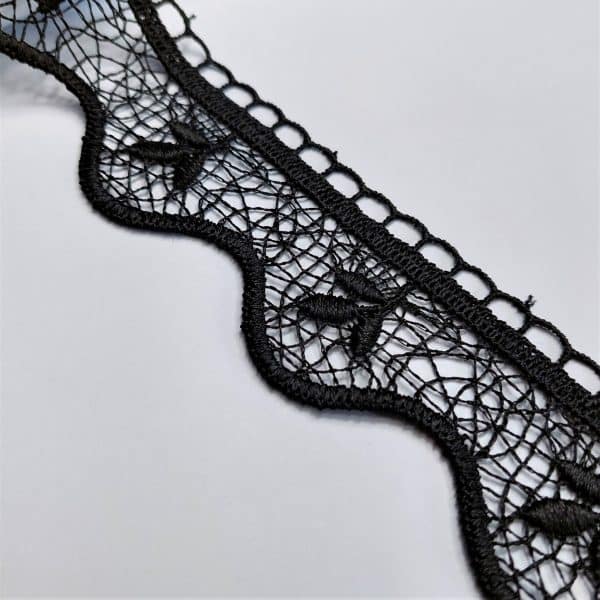 Czarna koronka na białym tle z misternym wzorem i falistym brzegiem, idealna do dekoracji lub mody.