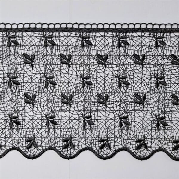 Czarna koronka z haftowanym wzorem liści na siateczkowym tle, elegancka i stylowa dekoracja tekstylna.