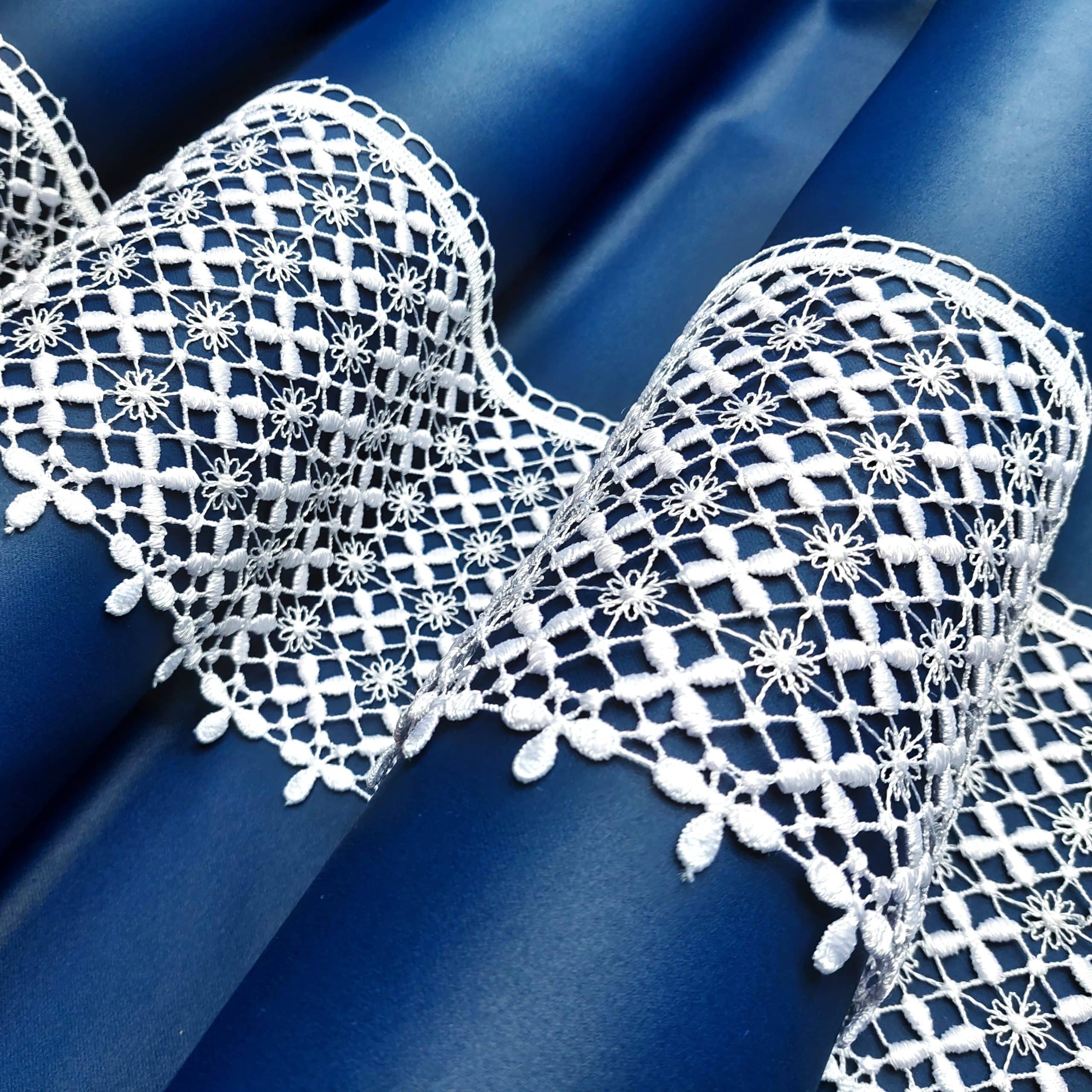 82690-15-1 Białe koronkowe wzory na niebieskim tle, elegancki haft z delikatnymi kwiatami.