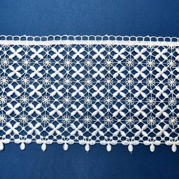 Biała koronka na niebieskim tle o skomplikowanym wzorze z motywami kwiatowymi, idealna do dekoracji.