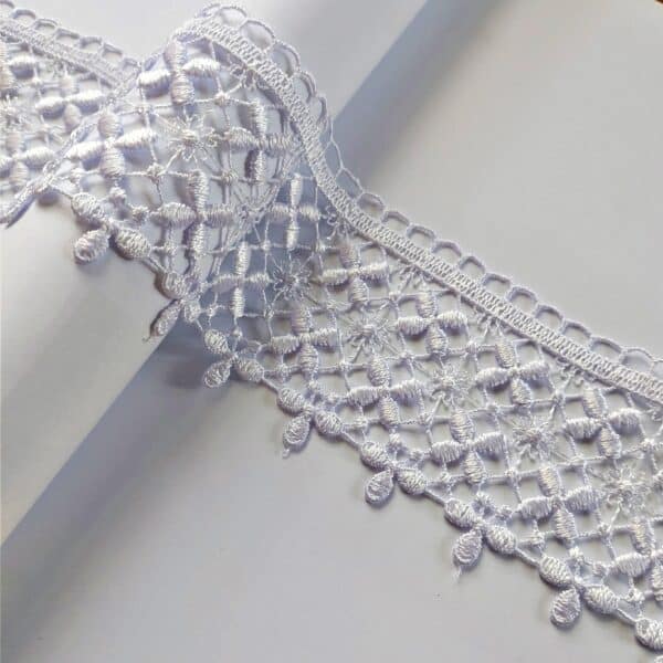 Koronkowa biała taśma dekoracyjna na białym tle, delikatny wzór kwiatowy, idealna do dekoracji.