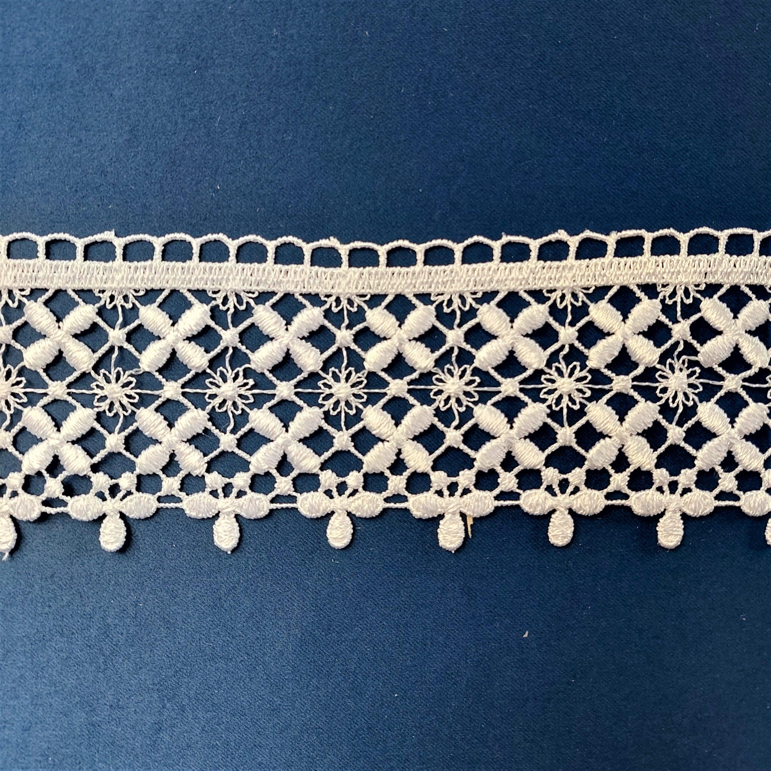 82690-7 3 Koronkowa tasiemka z misternym wzorem kwiatowym na niebieskim tle. Eleganckie rękodzieło do dekoracji i szycia.
