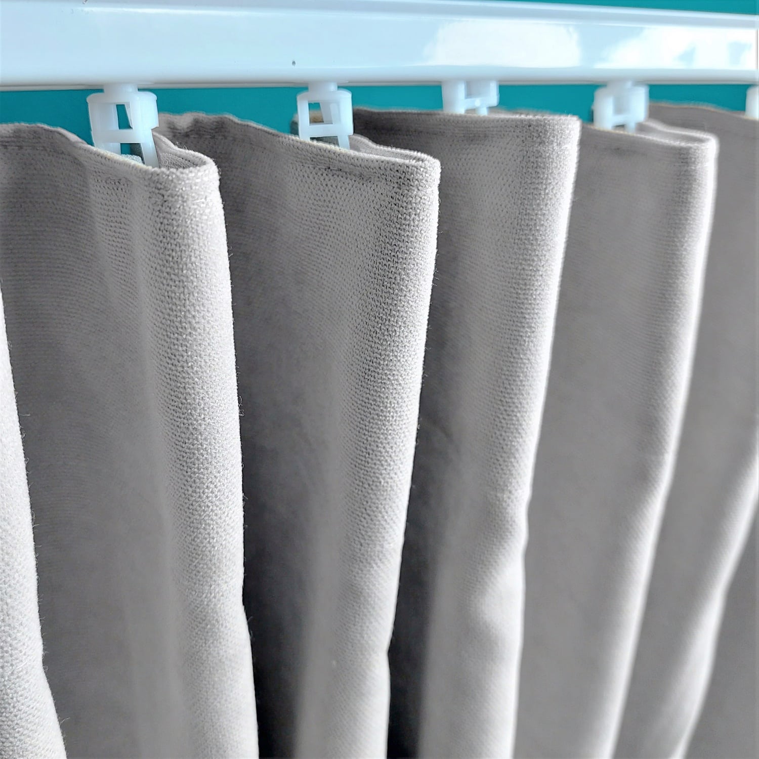 Marszczenie 3 10843_zamiana Zbliżenie na szare zasłony na białym karniszu, wnętrze nowoczesnego wystroju wnętrz.