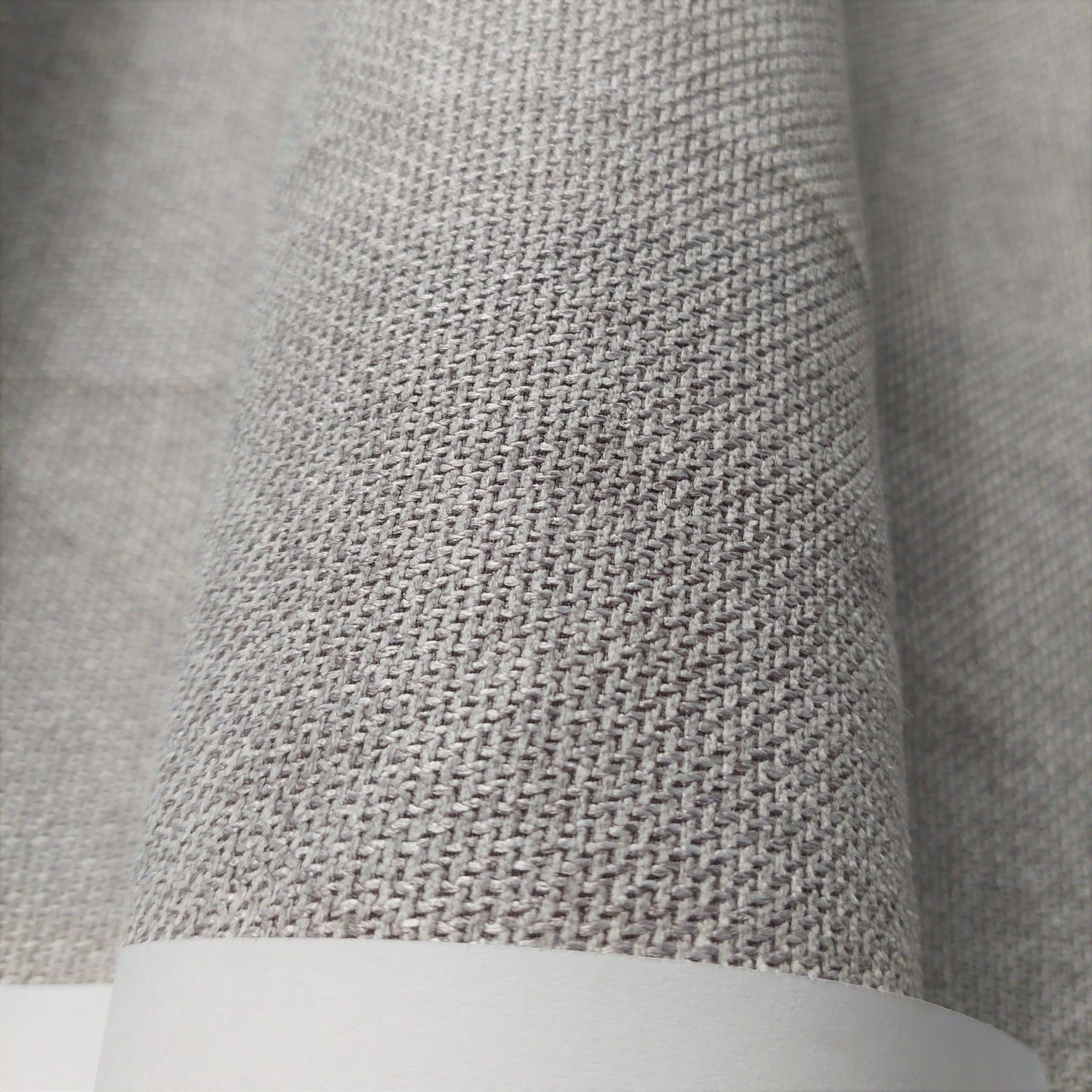 Szary materiał tkaninowy w zbliżeniu, widoczna faktura i splot włókien.