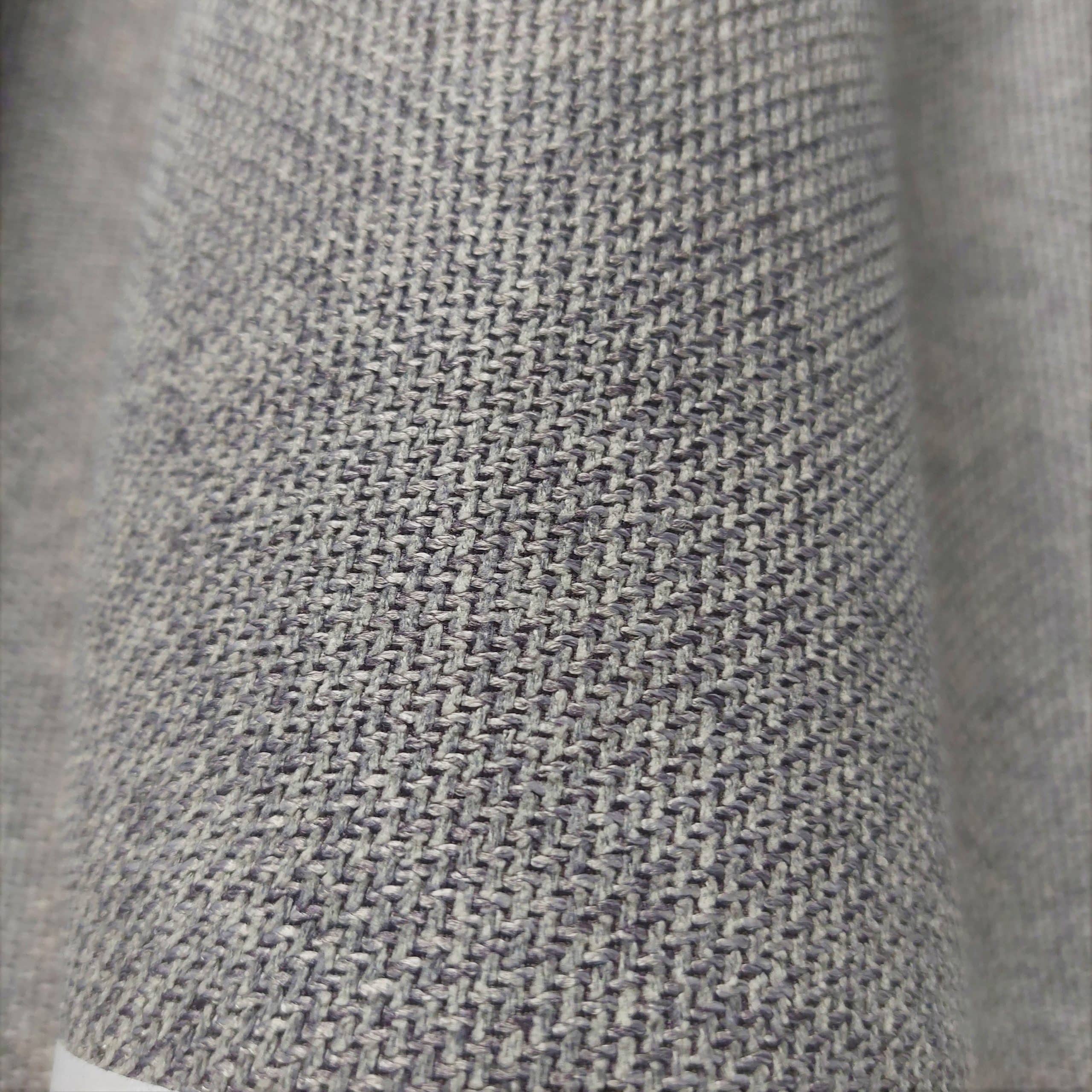 Zbliżenie na teksturę szarej tkaniny o drobnym splocie, detale materiału dekoracyjnego.