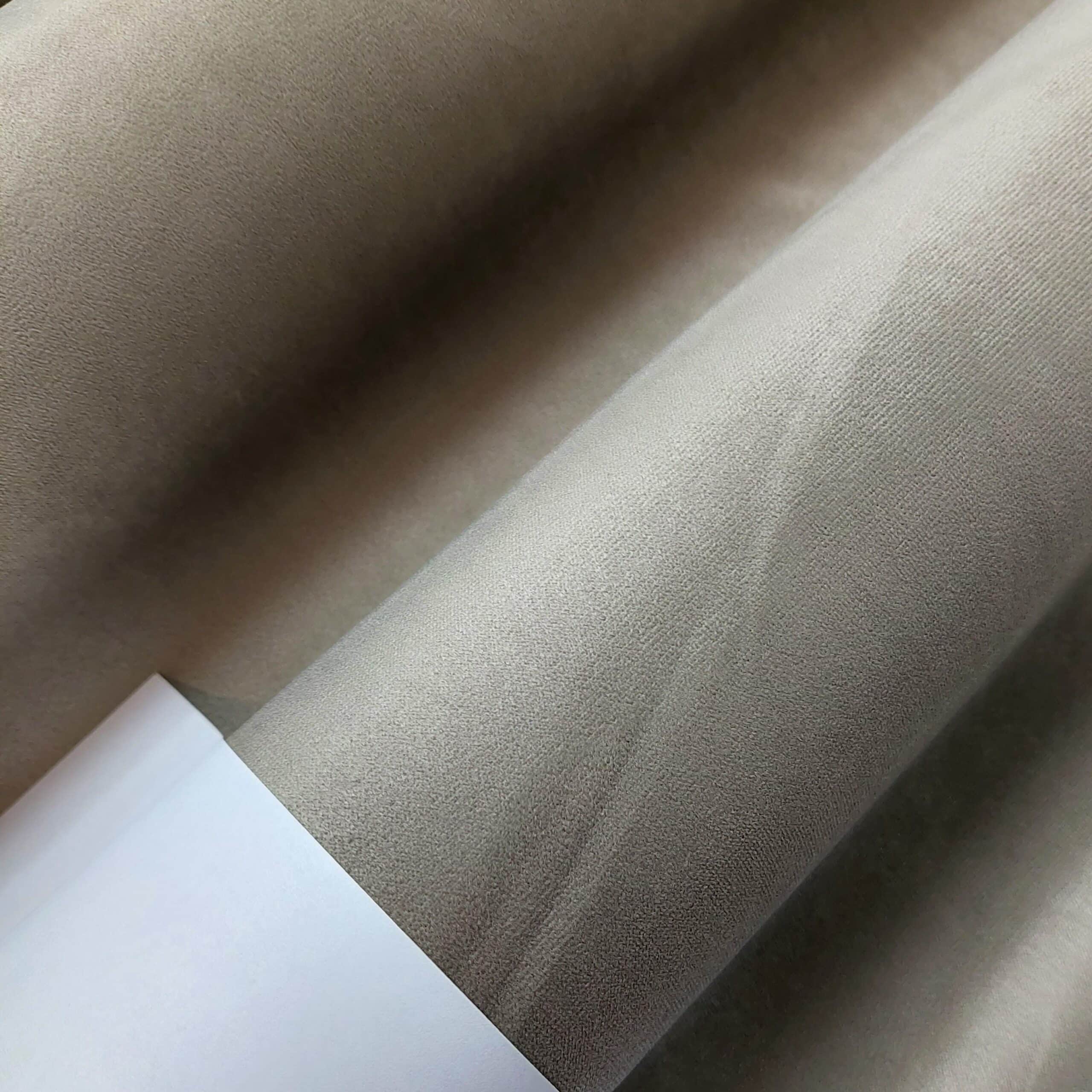 Tango 3 - 2 Zbliżenie beżowej tkaniny o gładkiej fakturze, nawiniętej na rolkę.