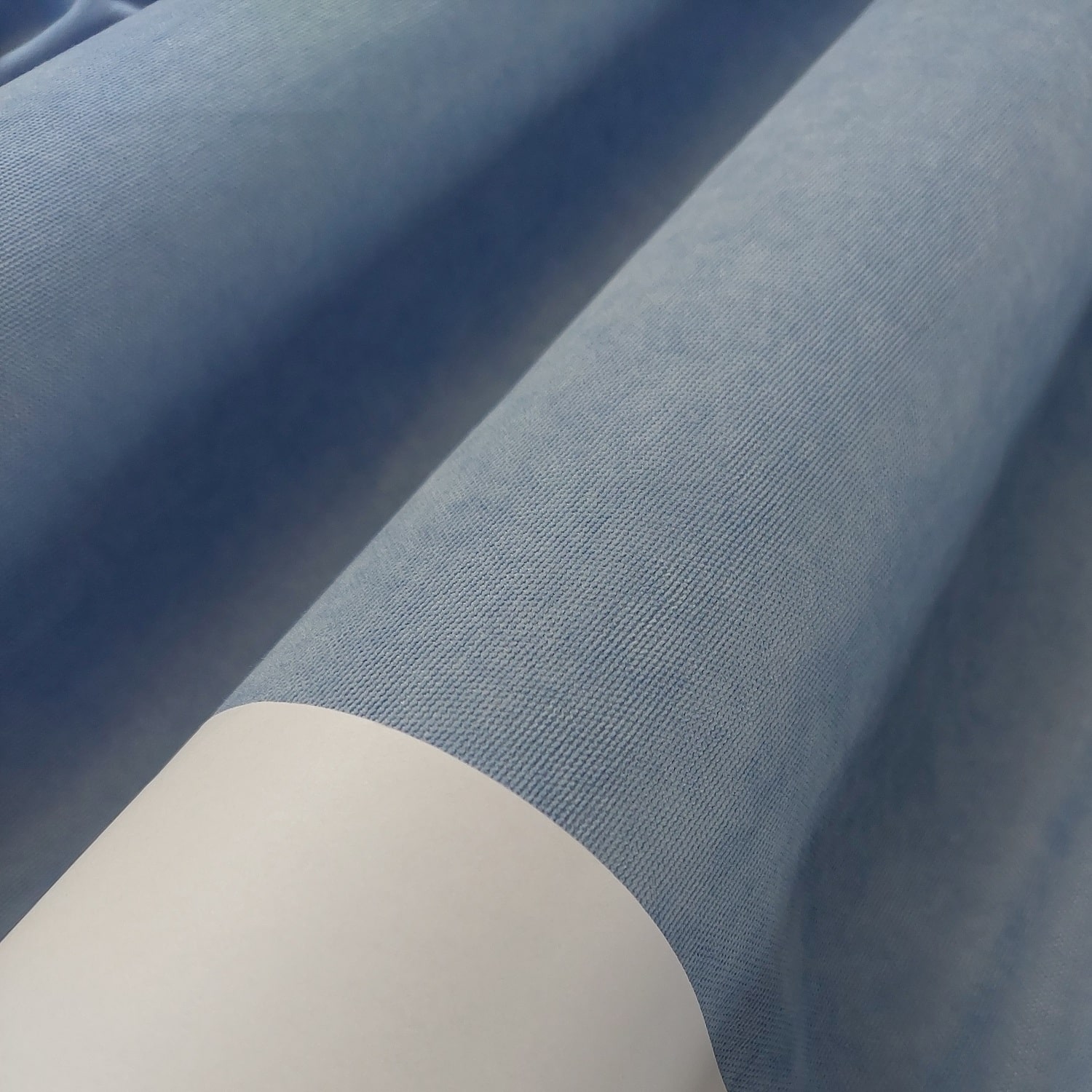 Wave 10271 nieb1 Niebieski materiał tekstylny w rolce, zbliżenie na strukturę tkaniny, gotowy do cięcia i szycia.