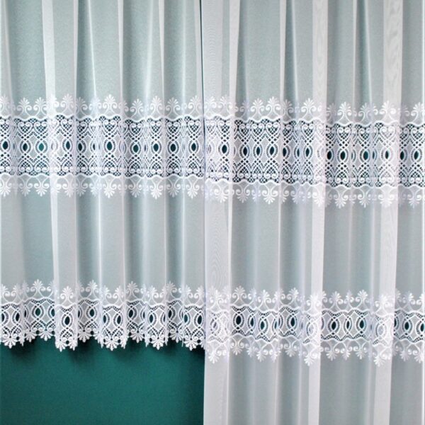 Białe firany z delikatnym wzorem na tle zielonej ściany, drewniana podłoga na dole.