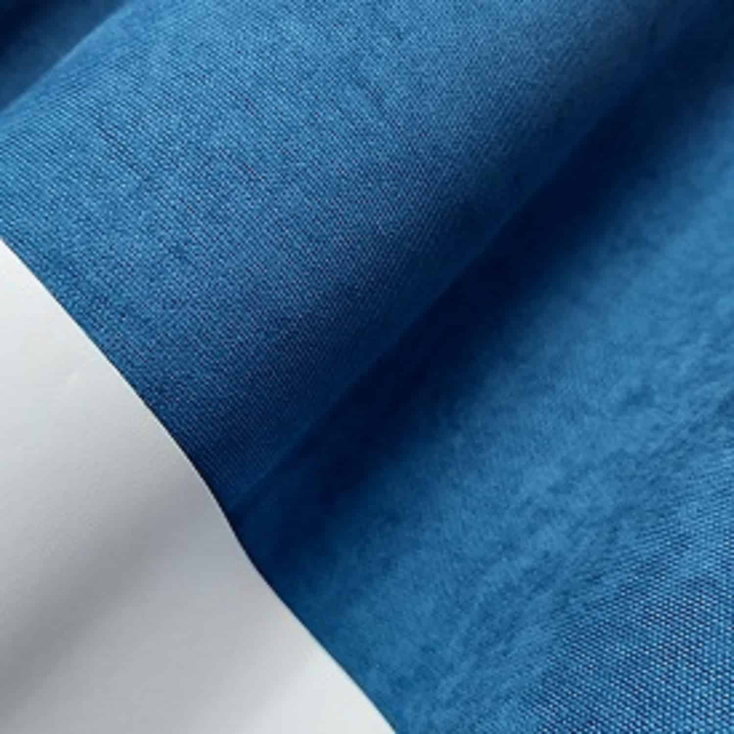 Niebieski materiał na zwiniętej rolce, tekstura tkaniny zbliżenie.