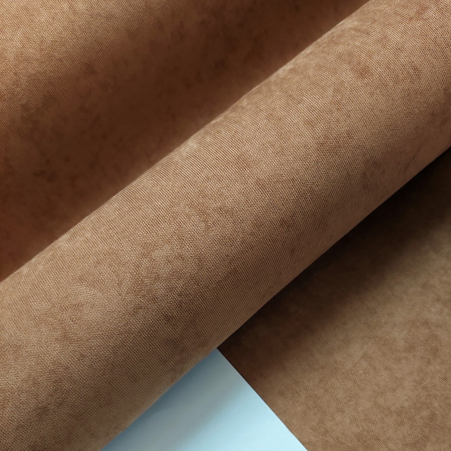 efe 14655 - 2 Beżowy materiał tapicerski o fakturze przypominającej zamsz, złożony w fałdy, ukazujący delikatną strukturę powierzchni.