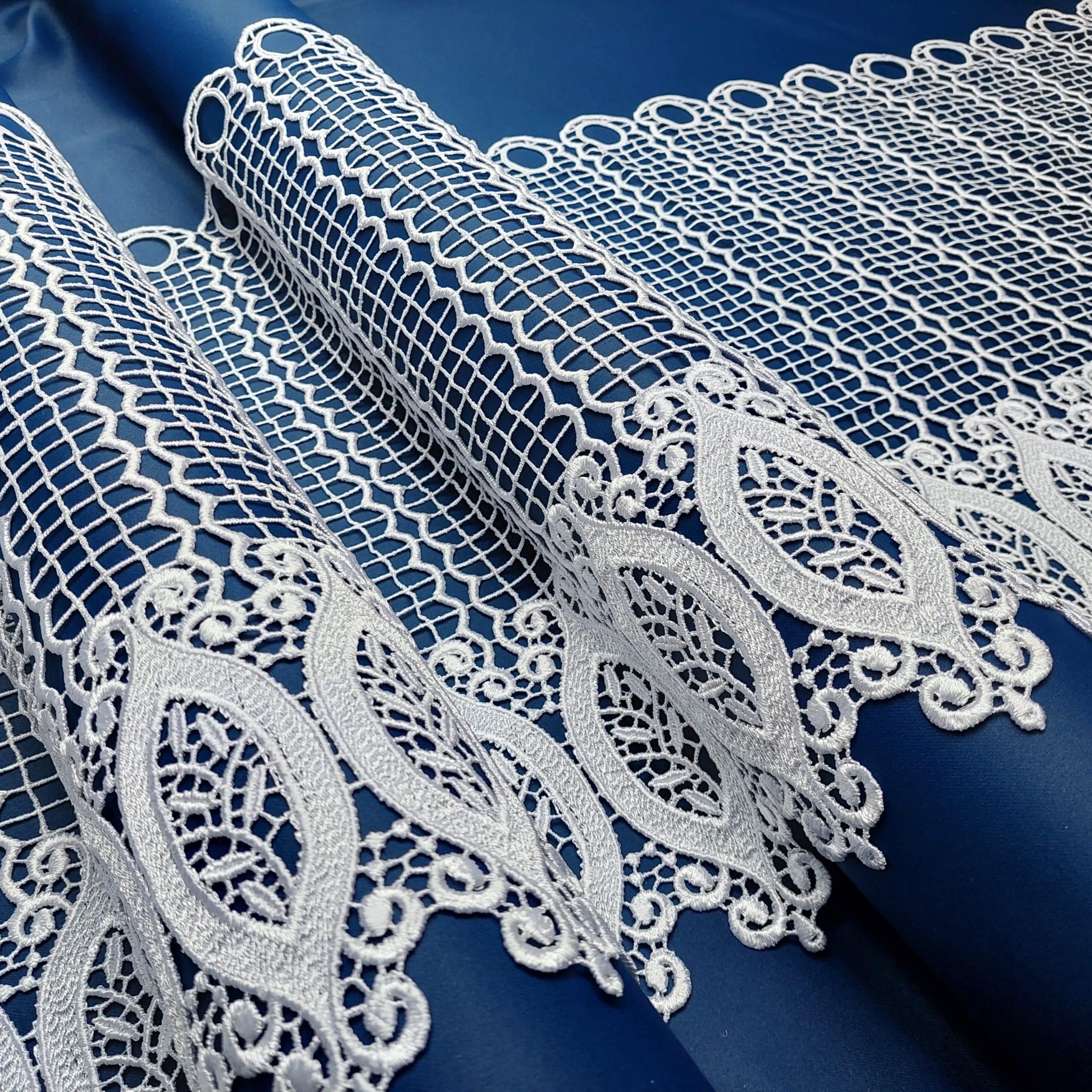 83130-45-1 Koronkowa tkanina na niebieskim tle, delikatne wzory o geometrycznych kształtach. Idealna do dekoracji wnętrz.