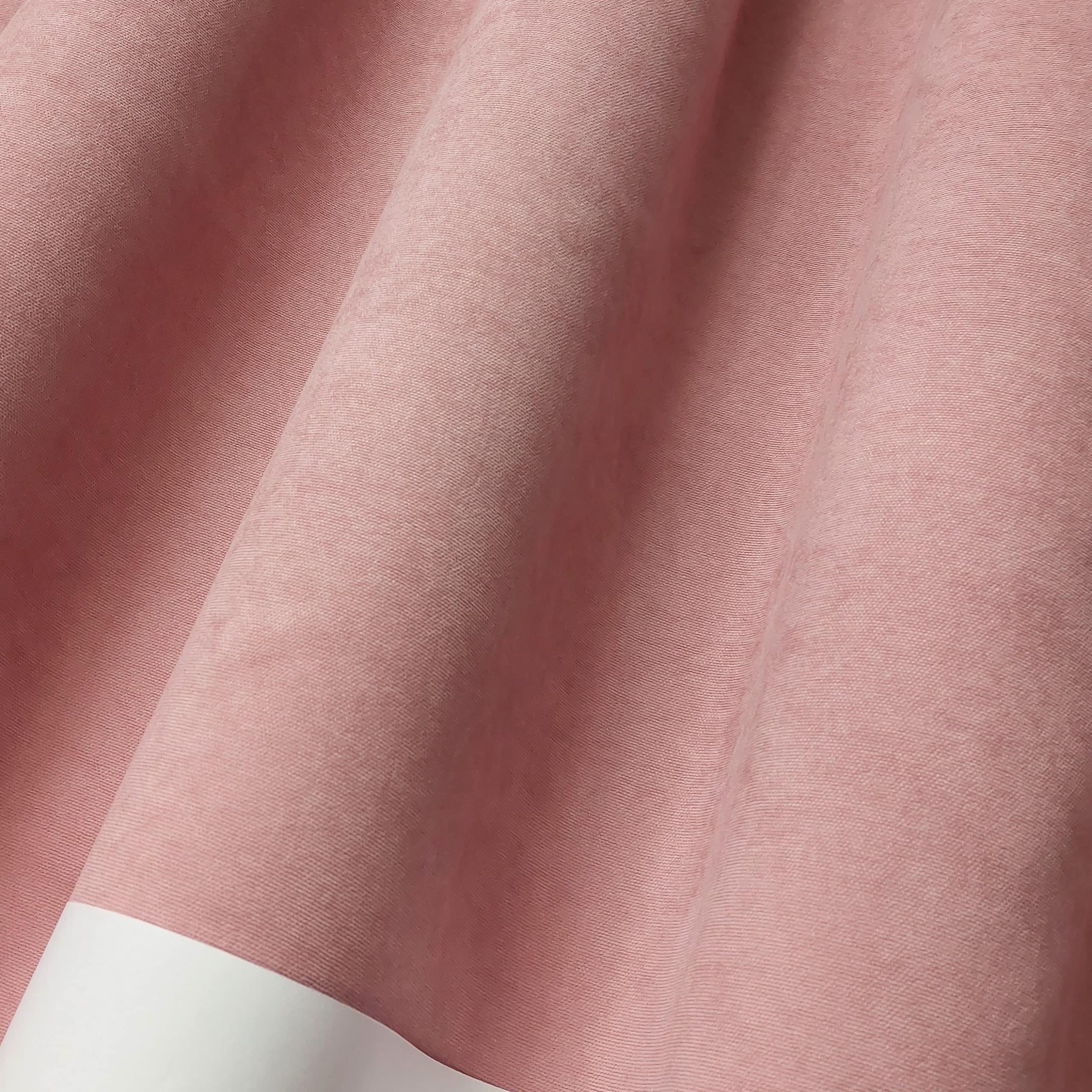 Różowa tkanina o gładkiej fakturze z białym brzegiem, zbliżenie na detale materiału.