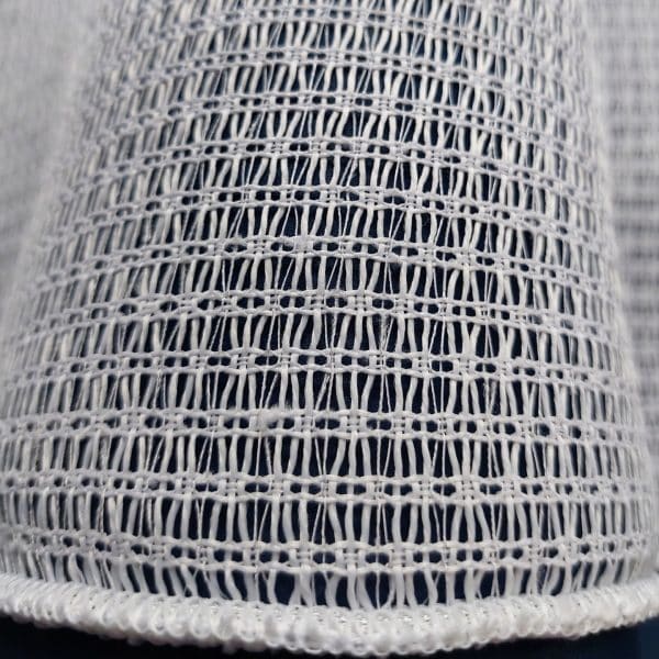 Biały materiał o strukturze siatki z bogatym wzorem tkaniny. Idealny do dekoracji i projektowania wnętrz.