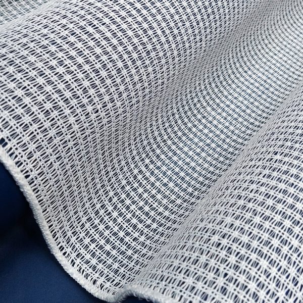 Biała, elastyczna tkanina o drobnym wzorze, idealna na lekkie zasłony lub dekoracje wnętrz.
