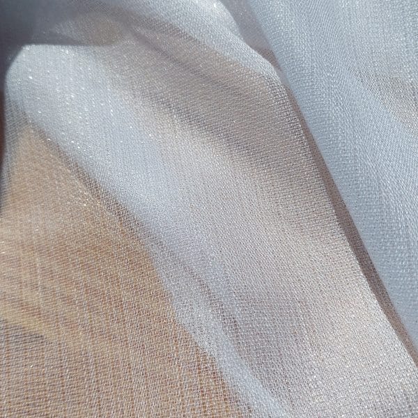 Przezroczysty materiał o błyszczącej fakturze, delikatnie falujący, przepuszczający światło.