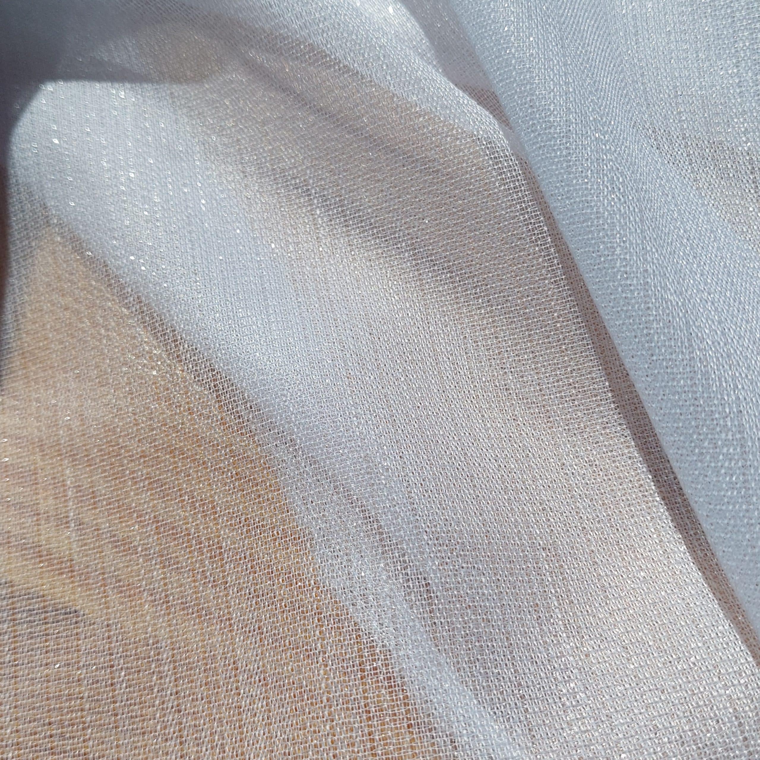 Przezroczysty materiał o błyszczącej fakturze, delikatnie falujący, przepuszczający światło.