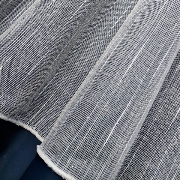Prześwitująca tkanina siatkowa na ciemnym tle, widoczna struktura materiału.
