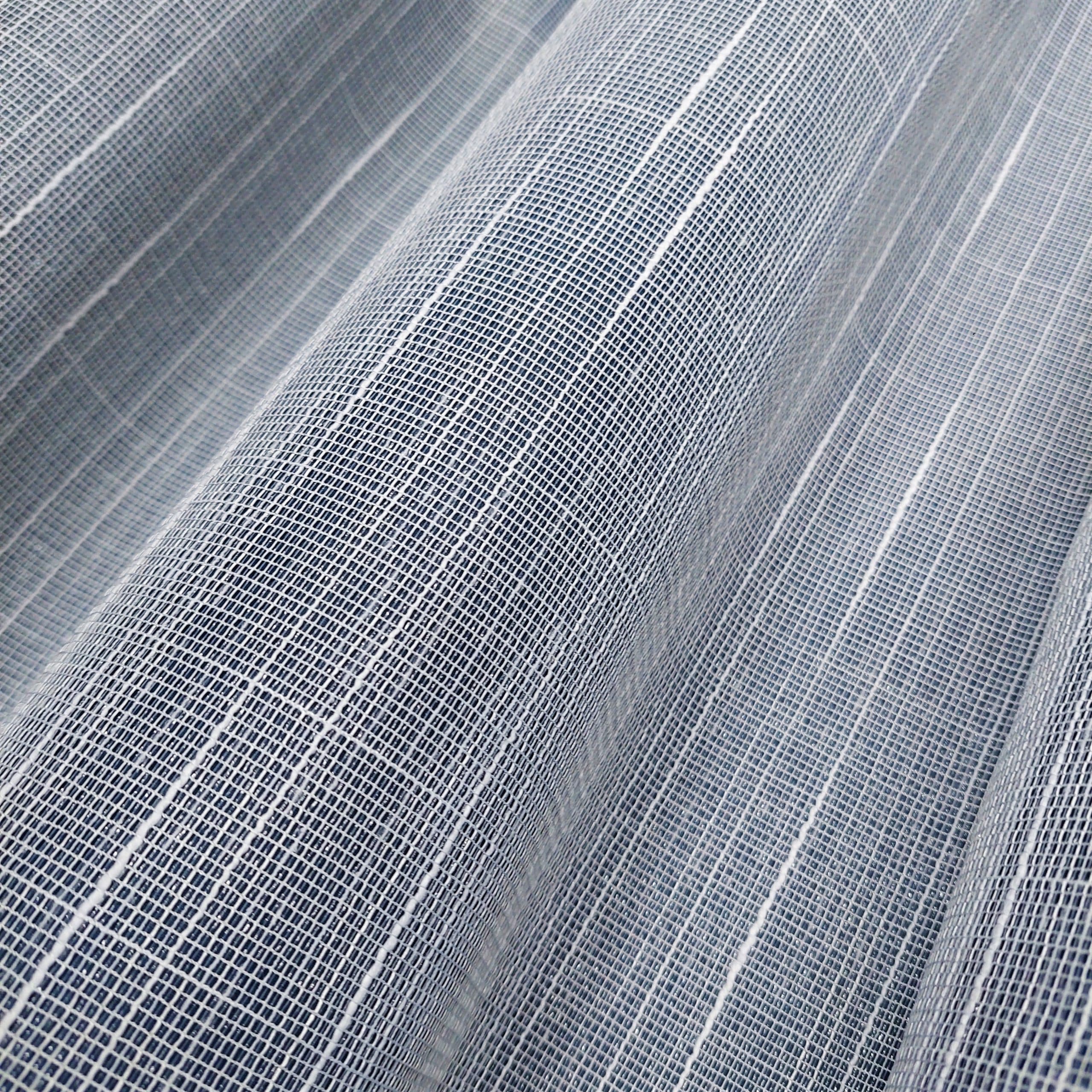 Zbliżenie na teksturę monochromatycznej tkaniny z drobnym, siateczkowym wzorem, idealna na zasłony.