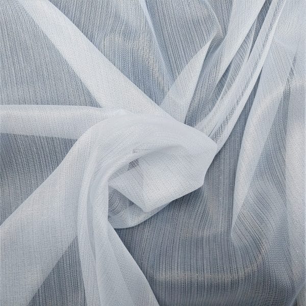 Biała tkanina tiulowa, delikatnie ułożona na szarym tle, tworzy subtelną i elegancką kompozycję.