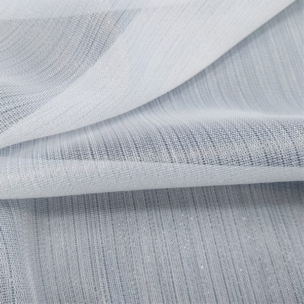 Przezroczysta biała tkanina z delikatnym wzorem, złożona w fale na jasnym tle.