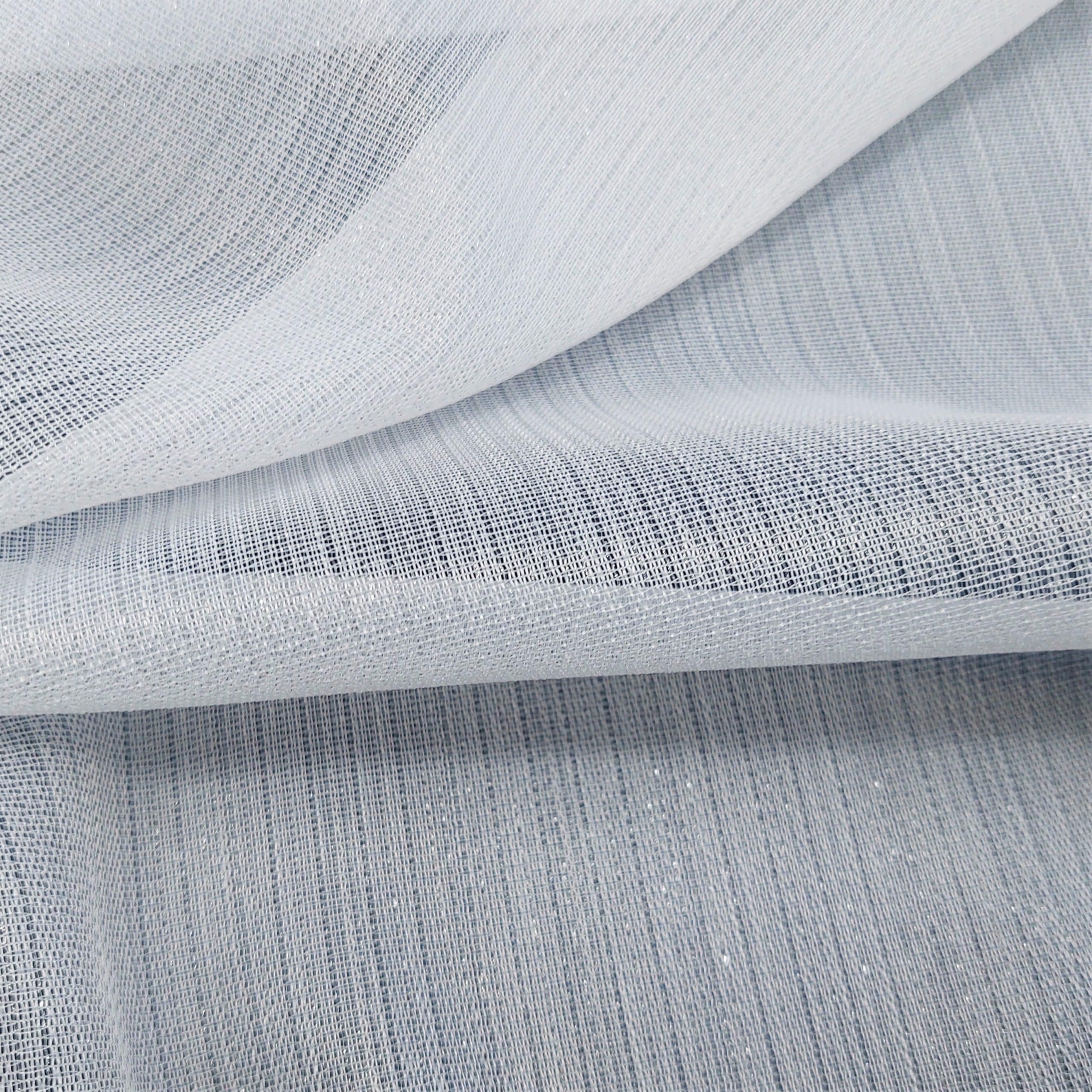Przezroczysta biała tkanina z delikatnym wzorem, złożona w fale na jasnym tle.