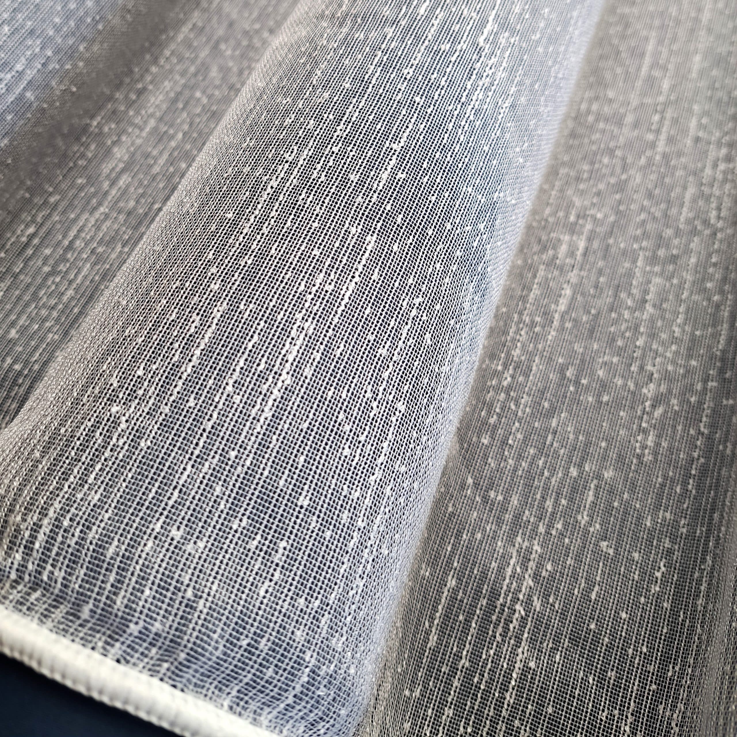 4035 SCANDI Firana Premium 300 cm biała Nowość w naszej kolekcji!! SCANDI Firana Premium Tkanina z kategorii PREMIUM. Fabryczna wysokość 300cm. Firana o strukturze "deszczyku" z delikatnymi pęczkami w nitce. Gęsty wyraźny splot przędzy z przegrubieniami w osnowie. Kolor: biały. Przyjemna w dotyku i dobrze układająca się. Średni stopień przejrzystości. Zakończona ołowianym obciążnikiem u dołu. Tkanina cięta z belki, wymaga obszycia! Niebagatelna tekstura przyciągnie uwagę każdego klienta szukającego nowych, prostych rozwiązań w dekoracjach okiennych. Tkanina łatwa w utrzymaniu i konserwacji. Prać w temperaturze do 30 stopni. 100% poliester Producent: Turcja Możliwość zamówienia bezpłatnej próbki przed zakupem. Charakterystyka SCANDI Firana Premium Firana SCANDI PREMIUM to wyjątkowy produkt z kategorii PREMIUM, idealnie wpisujący się w nowoczesne trendy dekoracji wnętrz.  Dodatkowo, tkanina posiada unikalną strukturę "deszczyku" z delikatnymi pęczkami w nitce, co nadaje jej niepowtarzalny wygląd. Gęsty, wyraźny splot przędzy z przegrubieniami w osnowie sprawia, że firana jest nie tylko estetyczna, ale również trwała. Kolor biały dodaje jej uniwersalności i elegancji, pasując do różnych stylów wnętrz, od skandynawskiego po minimalistyczny. Co więcej, tkanina jest przyjemna w dotyku i dobrze układająca się, co zapewnia jej nienaganny wygląd na oknie. Średni stopień przejrzystości firany SCANDI PREMIUM pozwala na przenikanie naturalnego światła, jednocześnie zapewniając odpowiedni poziom prywatności. Ponadto, firana jest zakończona ołowianym obciążnikiem u dołu, co gwarantuje, że zawsze będzie się ładnie układać i nie będzie się marszczyć. Tkanina jest cięta z belki i wymaga obszycia, co daje możliwość dopasowania jej do indywidualnych potrzeb użytkownika. Następnie, warto podkreślić, że firana SCANDI PREMIUM jest łatwa w utrzymaniu i konserwacji. Można ją prać w temperaturze do 30 stopni, co zapewnia jej długotrwałe użytkowanie bez utraty jakości. W rezultacie, jest to produkt nie tylko piękny, ale i praktyczny. Wybór firany SCANDI PREMIUM to inwestycja w jakość i estetykę.   Producentem tej tkaniny jest renomowana firma z Turcji, co dodatkowo potwierdza jej wysoką jakość i staranne wykonanie. W efekcie, firana SCANDI PREMIUM to produkt, który zadowoli nawet najbardziej wymagających klientów. Ogólnie rzecz biorąc, firana ta łączy w sobie nowoczesny design, funkcjonalność i łatwość utrzymania. Podsumowując, jest to idealny wybór dla osób ceniących sobie elegancję, trwałość i praktyczność w dekoracjach okiennych. Zachęcamy do zakupu naszych tkanin zasłonowych. Służymy pomocą w aranżacji. 