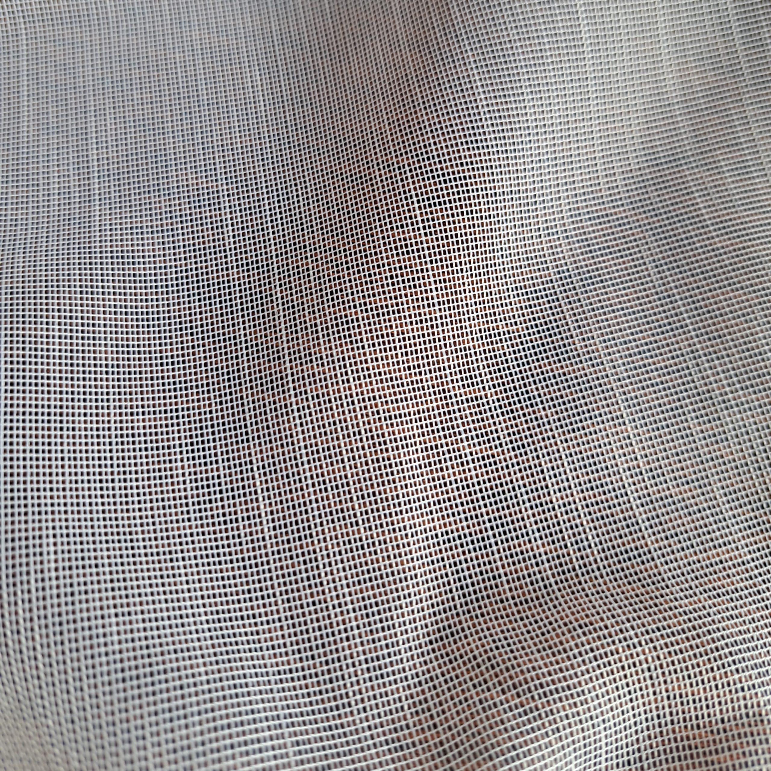 Tkanina siatkowa w zbliżeniu, pokazująca gęsty wzór i fakturę materiału.