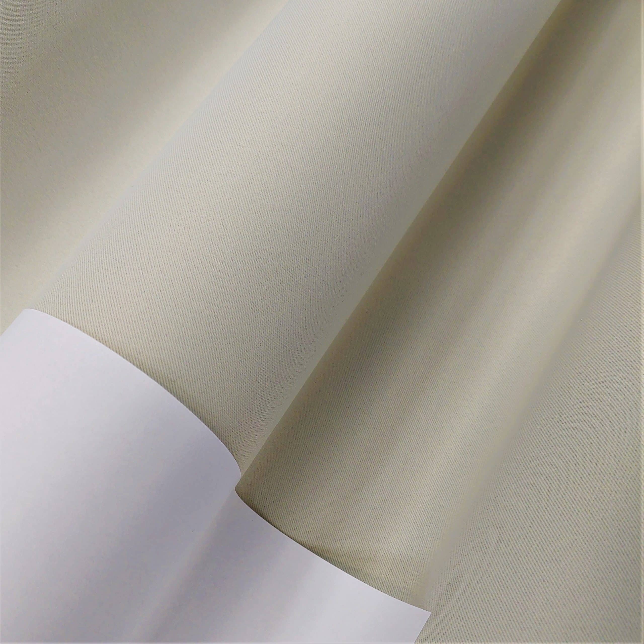 Rolki beżowego materiału na białym tle, zbliżenie przedmiotu.