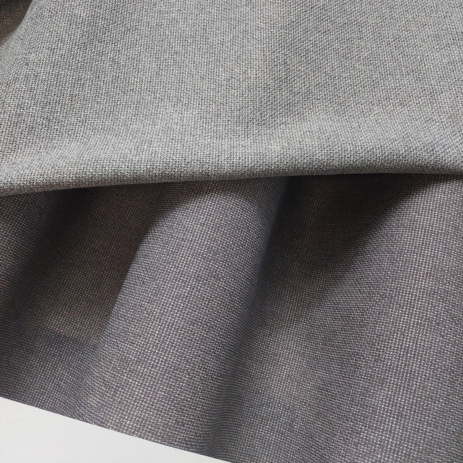 NS 18 - 3 P-L Szara tkanina z widocznym splotem, ułożona w fałdy. Idealna na zasłony lub odzież.