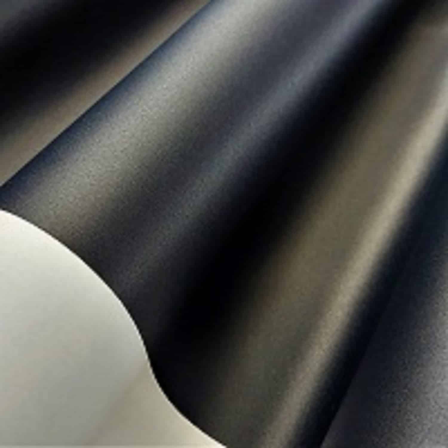 Czarna satynowa tkanina, złożona w delikatne fale, lśniąca pod światłem, elegancki materiał dekoracyjny.