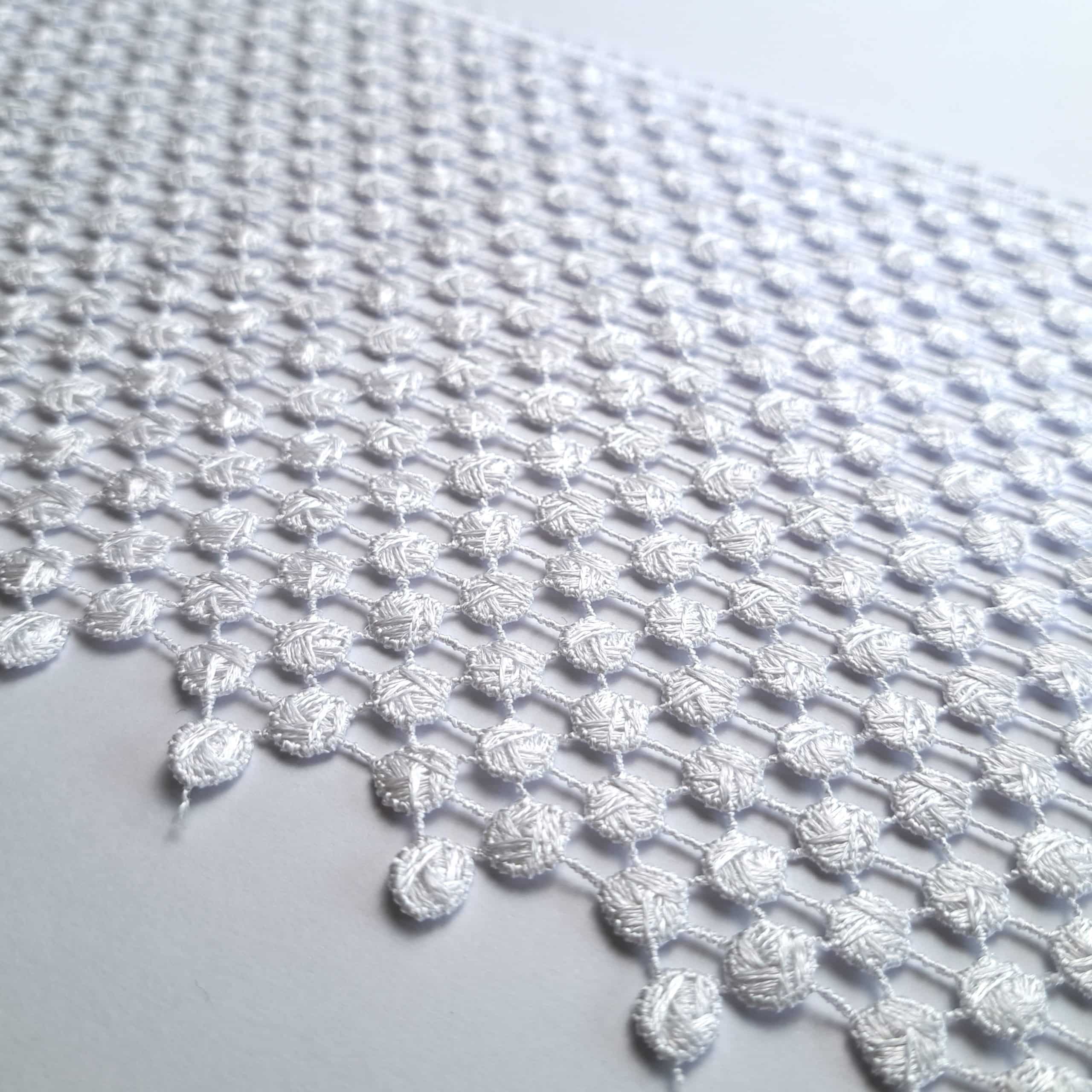 3236-20 2 Biała siatka z koronkowym wzorem na tle, detal artystyczny i tekstylne rękodzieło.