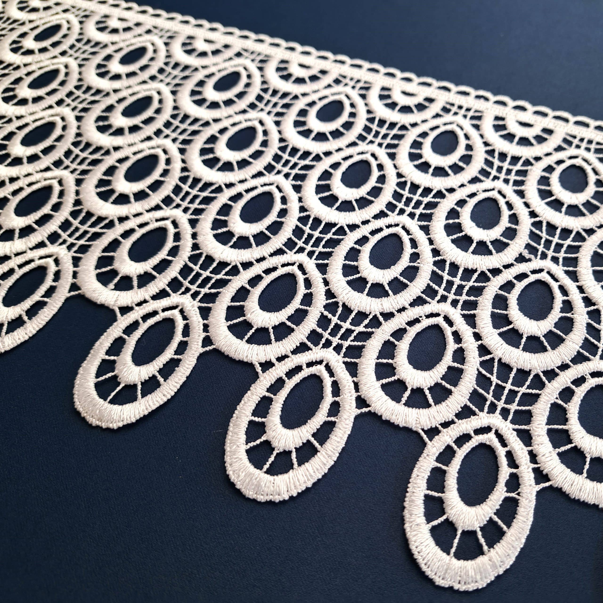 Koronkowy bieżnik z owalnym wzorem na ciemnym tle, elegancki akcent do dekoracji wnętrza.