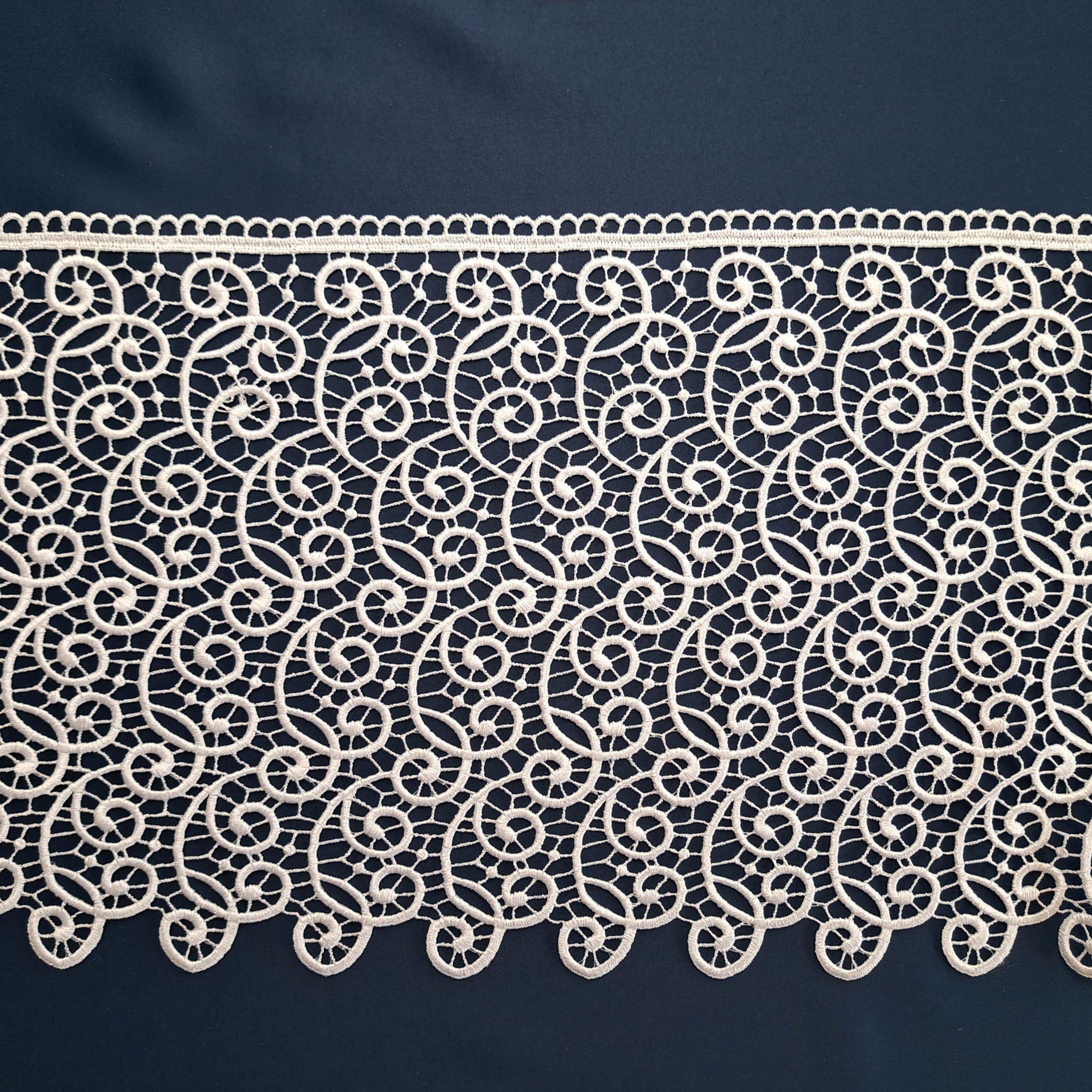 Koronkowy wzór na ciemnym tle, delikatna siateczka i ornamenty, elegancki design tekstyliów.