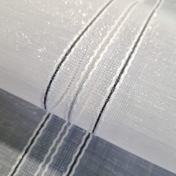 Firana nowoczesna pionowe pasy czarny-szary-czarny 300cm Firana fantazyjna pionowe pasy 300cm. Tkanina o wysokości 300cm +/- 3% tolerancja. Materiałem bazowym jest sable z połyskiem. Niepowtarzalnego charakteru nadają tkaninie pionowe pasy haftu (ok. 0,5cm szerokości) z wplecioną czarną nicią na dwóch skrajnych szlakach. Odległość miedzy pasami haftu to około 16cm. Tkanina dobrze układająca się. Średni stopień przejrzystości. Ołowiany obciążnik na dole firany. Polecana na proste firany, upięia oraz na rolety rzymskie. Tkanina cięta z belki, wymaga obszycia!! Łatwa w utrzymaniu i konserwacji. Prać w temperaturze do 30 stopni. 100% poliester. Oryginalny produkt turecki. Zachęcamy do zakupu naszych tkanin zasłonowych. Służymy pomocą w aranżacji.  Zachęcamy do śledzenia naszego profilu na FB. Firana fantazyjna z pionowymi pasami haftu Firana z pionowymi pasami haftu z wplecioną czarną nicią na dwóch skrajnych szlakach to elegancka i nowoczesna dekoracja okienna. Dodaje wnętrzu wyrafinowanego charakteru, łączy w sobie elegancję i nowoczesność. Jej delikatna tkanina, subtelne hafty i kontrastujące akcenty sprawiają, że jest idealnym wyborem do różnych wnętrz, w tym salonu, sypialni i gabinetu. Dzięki swojej uniwersalności i funkcjonalności, firana ta będzie nie tylko piękną, ale i praktyczną ozdobą każdego pomieszczenia. Firana fantazyjna pionowe pasy 300cm – Dla Kogo? Firana fantazyjna to doskonały wybór dla osób ceniących oryginalność, kreatywność i unikalny styl. Krótko mówiąc, jest to element dekoracyjny, który doda charakteru każdemu wnętrzu. Warto dodać, że jej uniwersalność i funkcjonalność sprawiają, że jest to rozwiązanie idealne dla różnych przestrzeni i grup odbiorców. Oprócz tego, firany fantazyjne są praktyczne i łatwe w utrzymaniu, co czyni je jeszcze bardziej atrakcyjnym wyborem. Z kolei w połączeniu z innymi elementami dekoracyjnymi, mogą stworzyć spójną i harmonijną aranżację. Dlatego też, firany te są polecane dla wszystkich, którzy pragną wyróżnić swoje wnętrze i nadać mu wyjątkowego charakteru.