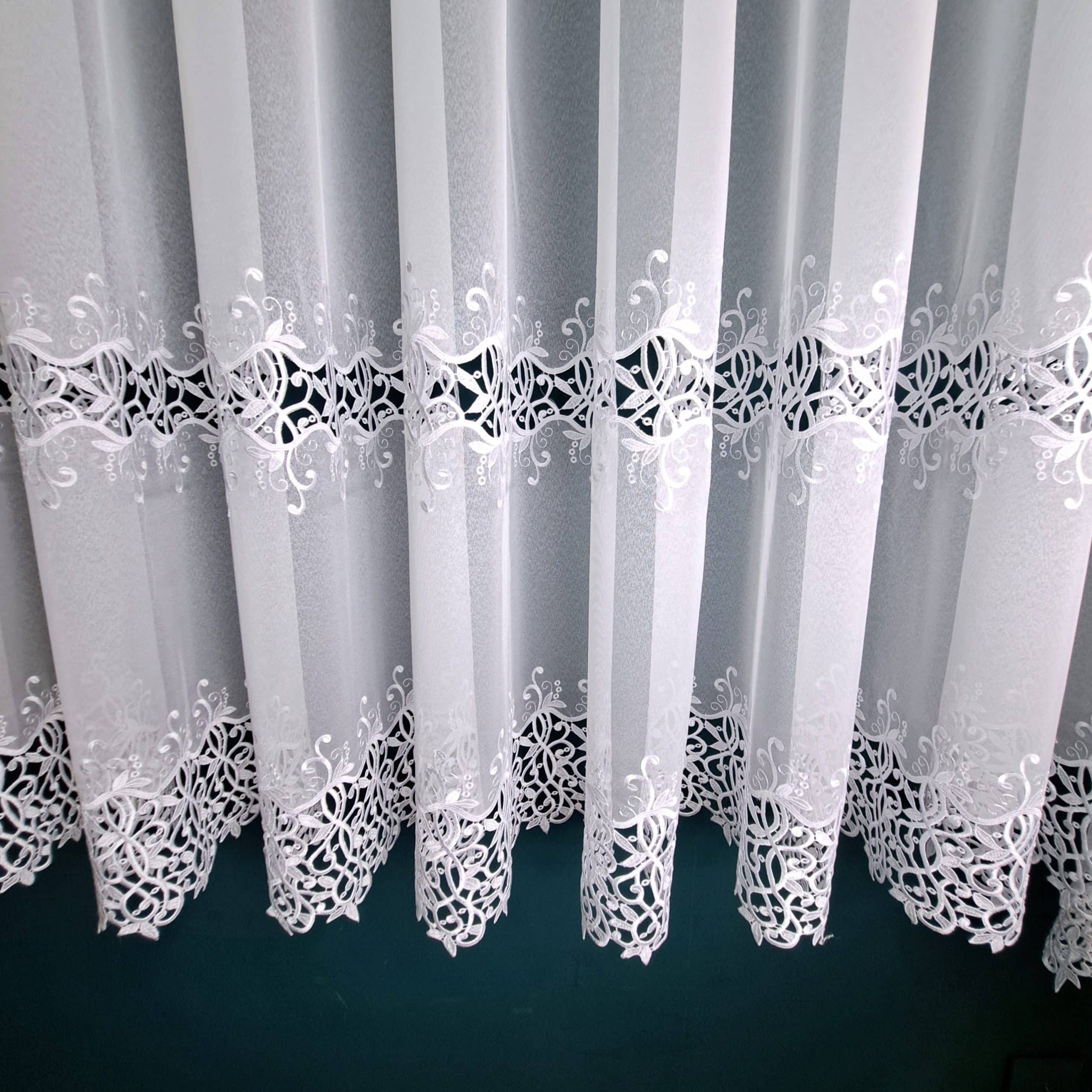 Firana haftowana biała 110 - 180 cm Długość 180cm  +/- 3% tolerancji. Firana z dwoma szlakami efektownego haftu. Wykonana na podkładzie klasycznej markizety. Szerokość dolnej aplikacji 20-25cm; górnej 18-22cm; odległość między szlakami ok. 23cm. Średni stopień przejrzystości. Miękka i przyjemna w dotyku. Tkanina cięta z belki, wymaga obszycia. Łatwa w utrzymaniu i konserwacji. Prać w temperaturze do 30 stopni. 100% poliester. Producent: Turcja Aplikacja chętnie kupowana przez naszych klientów. Zapraszamy :)