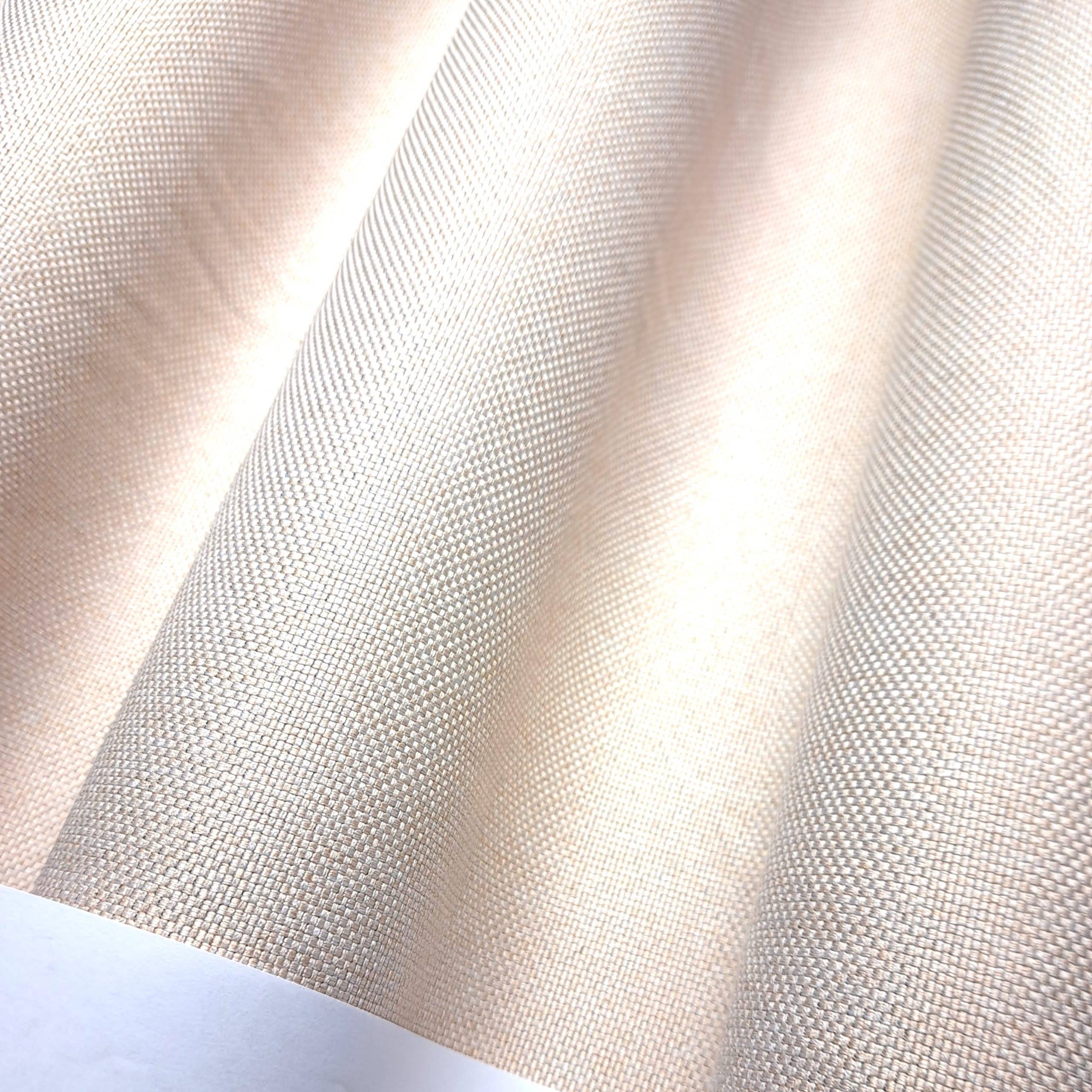 Beżowa tkanina z wyraźną fakturą, falująca w delikatnym świetle.