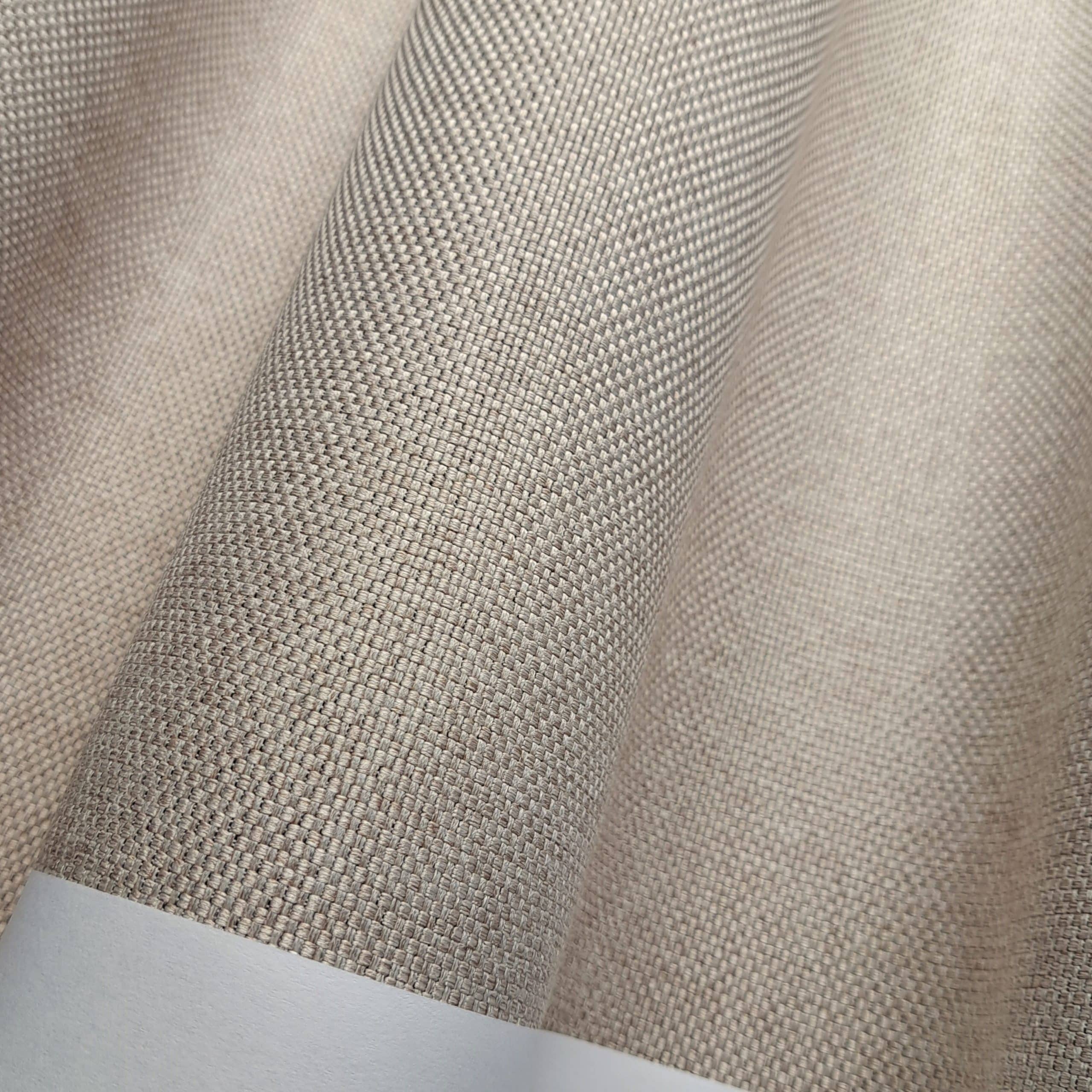 Beżowy materiał z bliska, tekstura tkaniny o drobnym splocie, zasłona lub tkanina dekoracyjna.