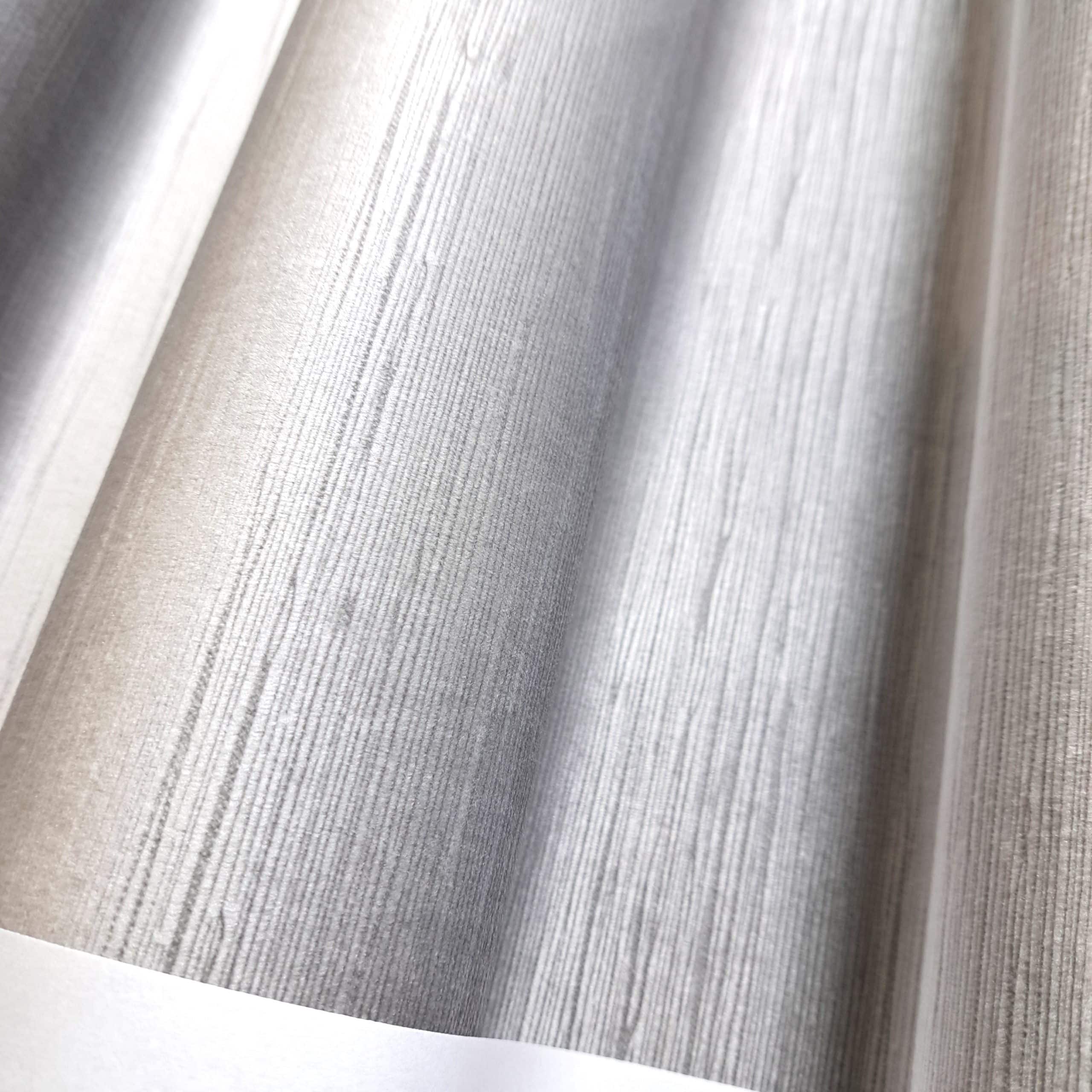 Szary, falisty materiał z teksturą przypominającą drewno, ukazany w zbliżeniu.