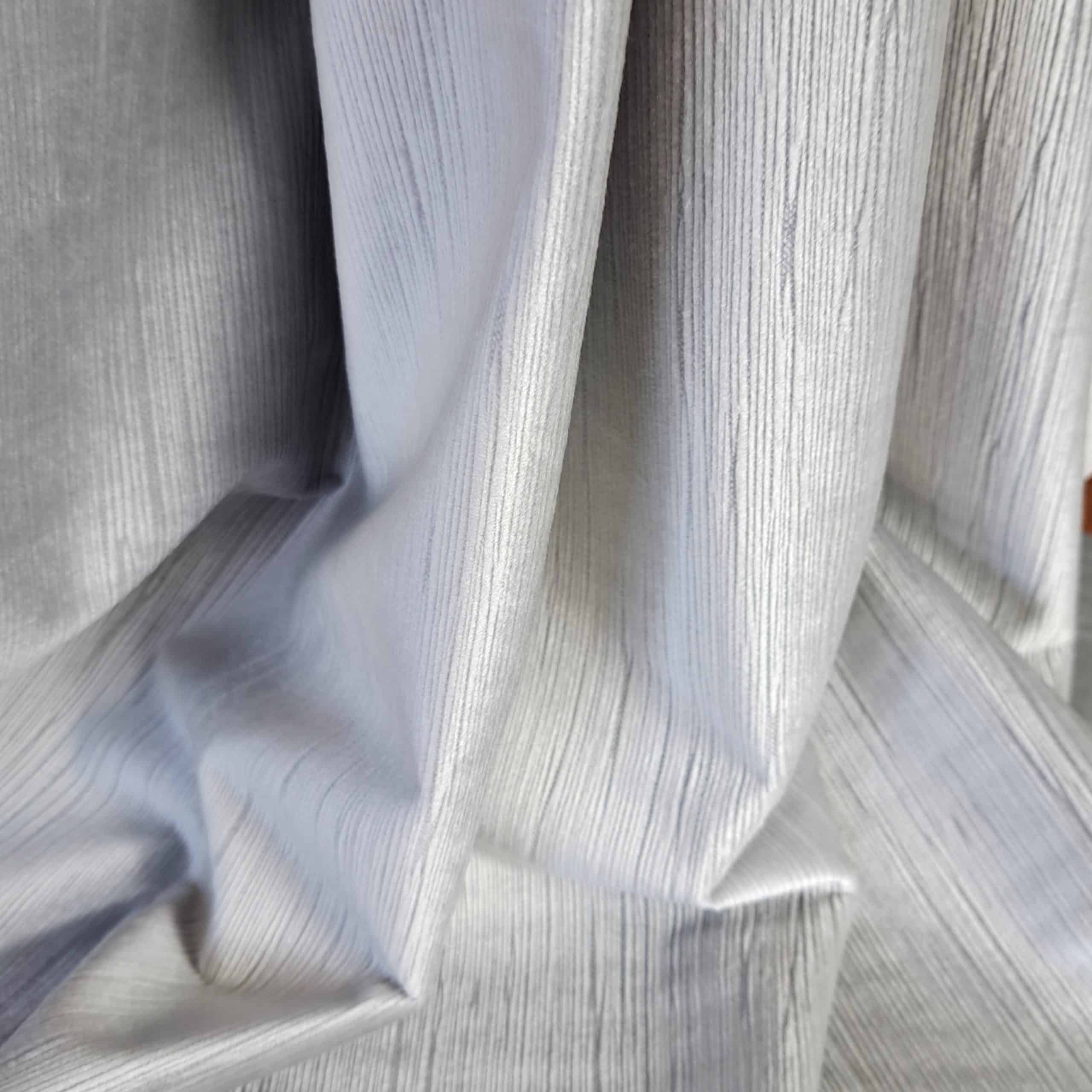 eden 10 - 14 Srebrzysta, teksturowana tkanina o delikatnych fałdach, podkreślająca elegancki wygląd i nowoczesny styl.