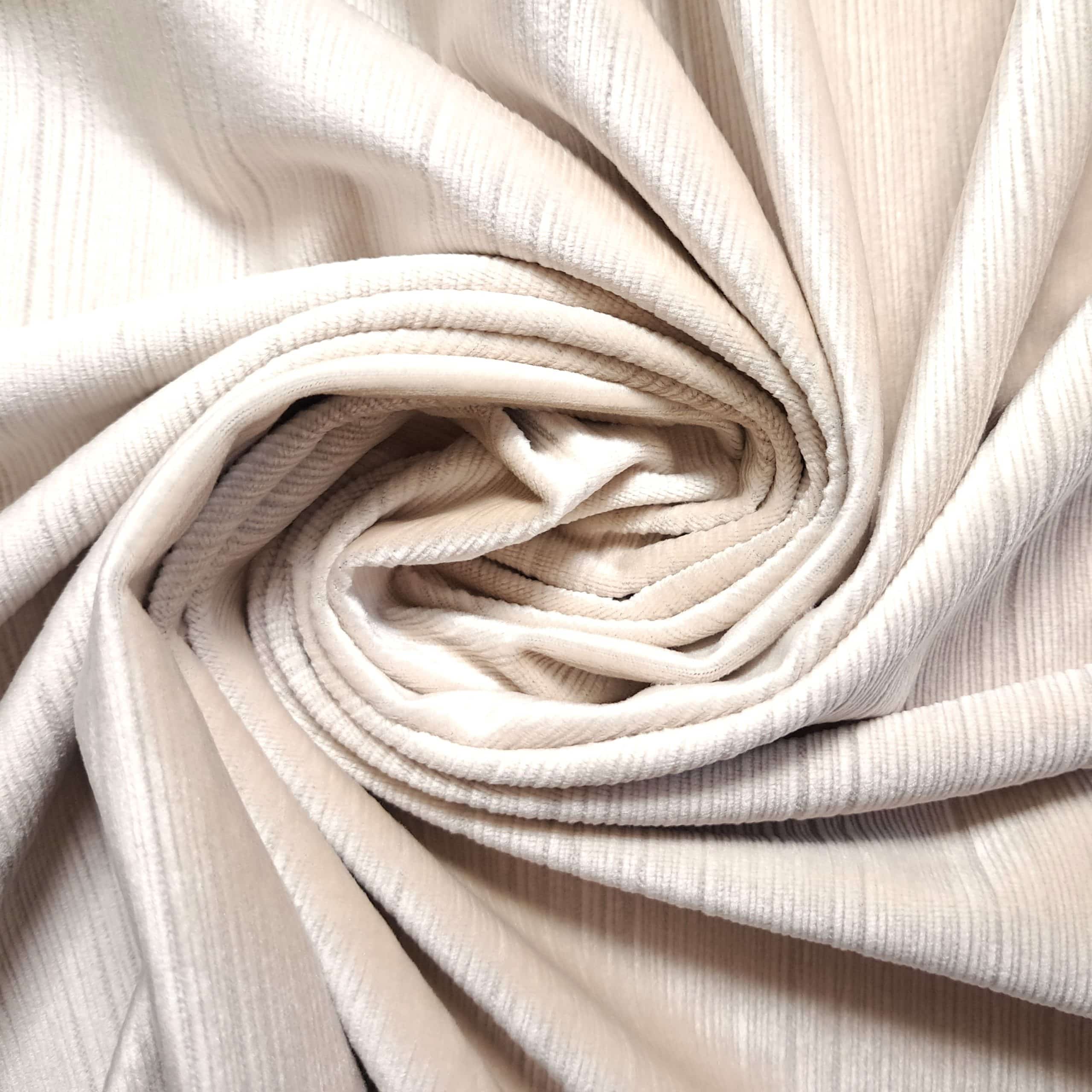 Beżowy materiał tekstylny w formie zwojów o teksturowanej powierzchni w zbliżeniu.