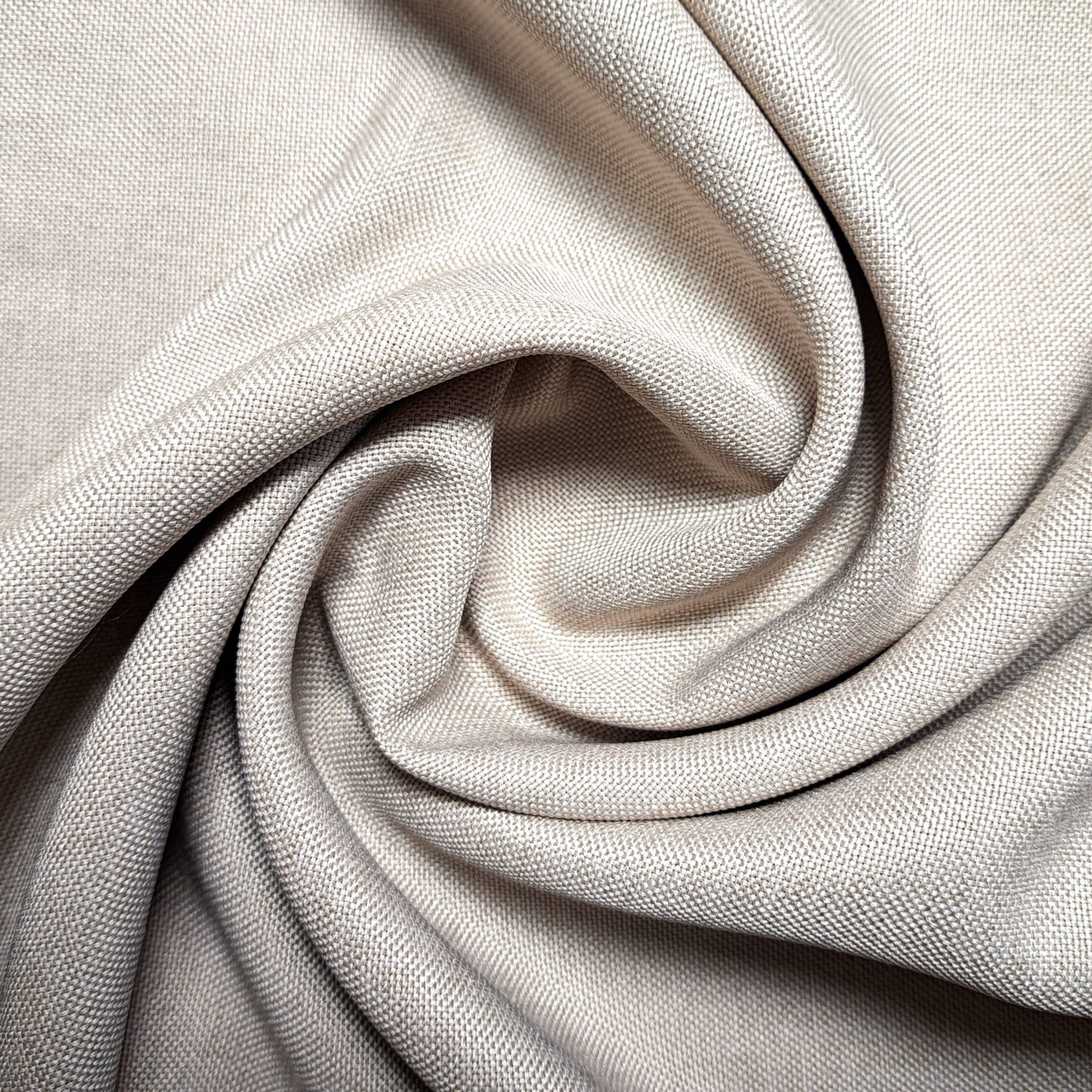 Beżowa tkanina lniana ułożona w efektowną spiralę, pokazująca teksturę i wzór materiału.