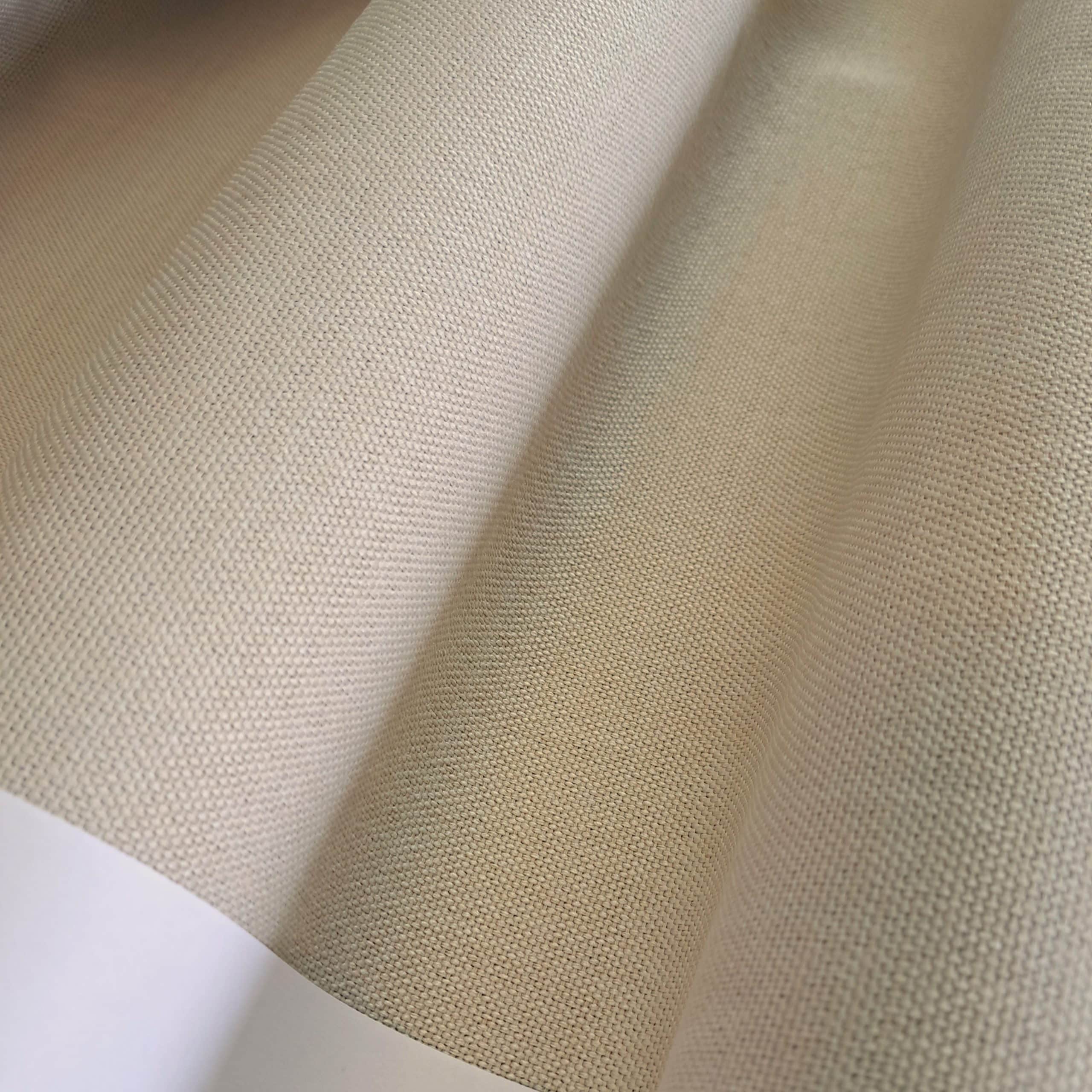 Zbliżenie na teksturę jasnobeżowego materiału o drobnym splocie, tworzącego delikatne fale.